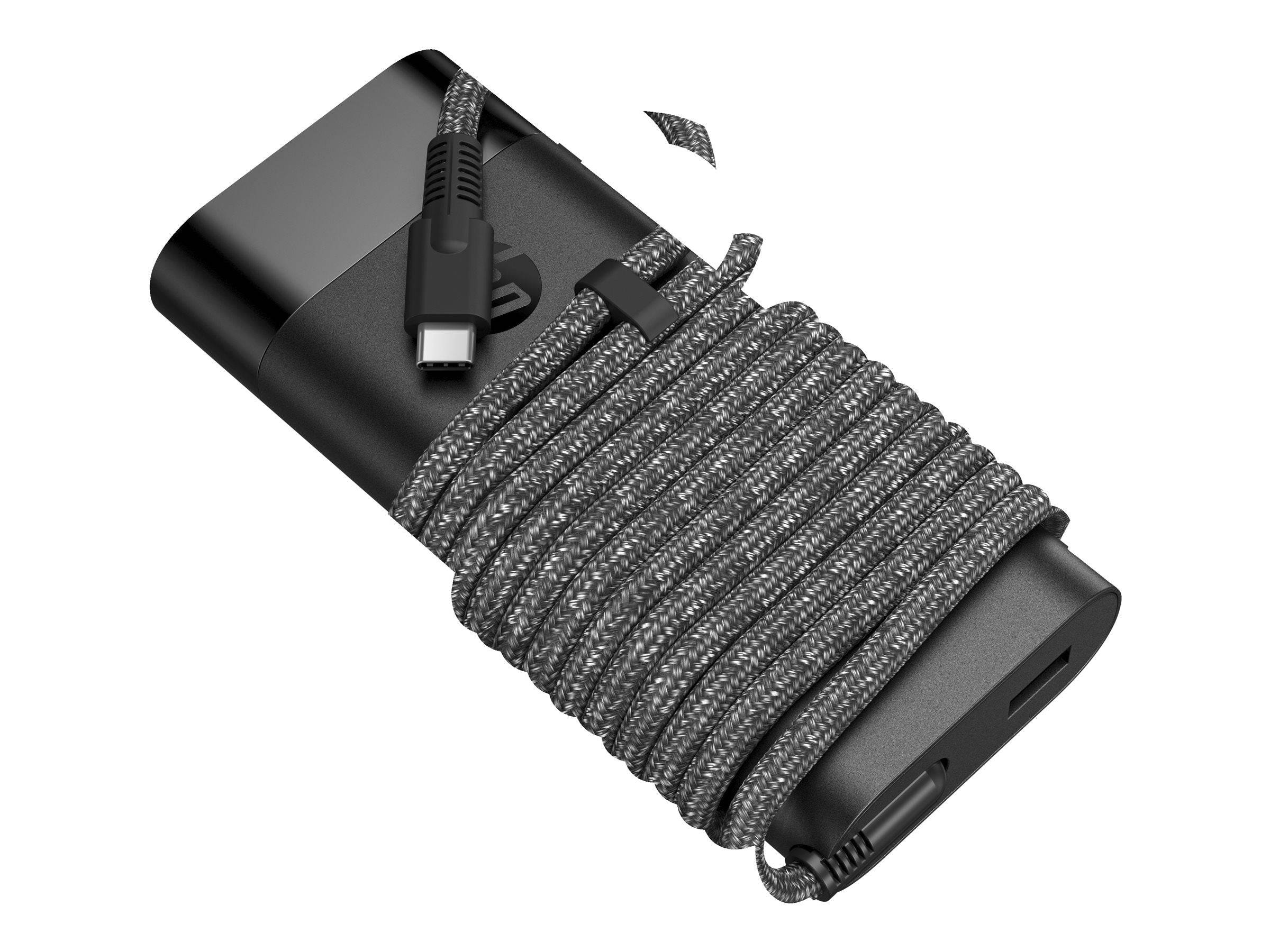 Czarny power bank z owiniętym wokół niego szarym plecionym kablem. Białe tło.