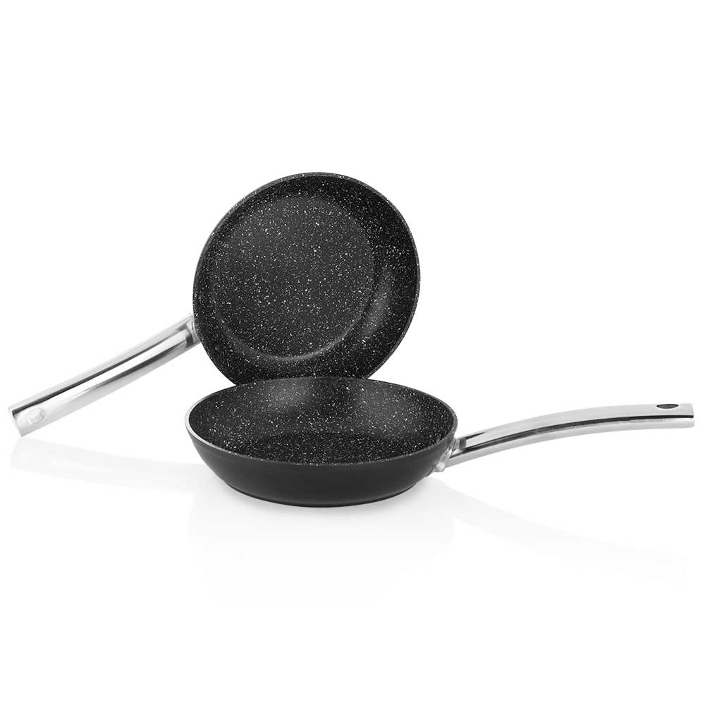 Dwie czarne patelnie z nakrapianym wnętrzem i srebrnymi uchwytami na białym tle.