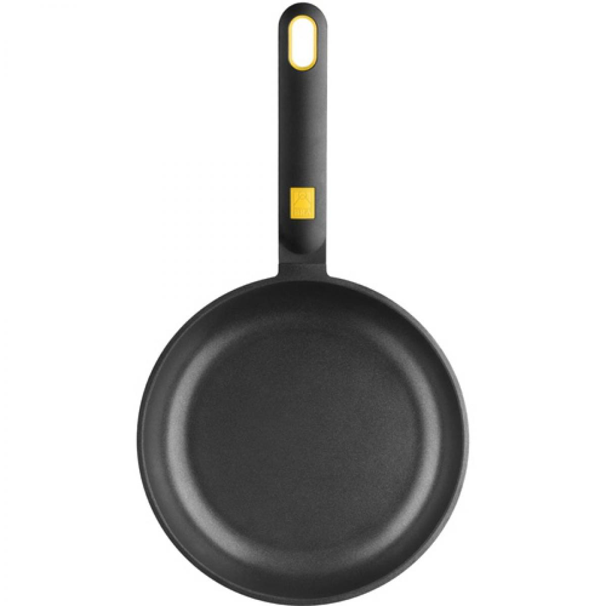 Czarna patelnia z długim uchwytem i żółtym akcentem.