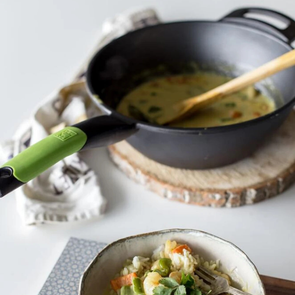 Wok z jedzeniem i drewnianą łyżką na kawałku drewna. Ryż i krewetki w misce.