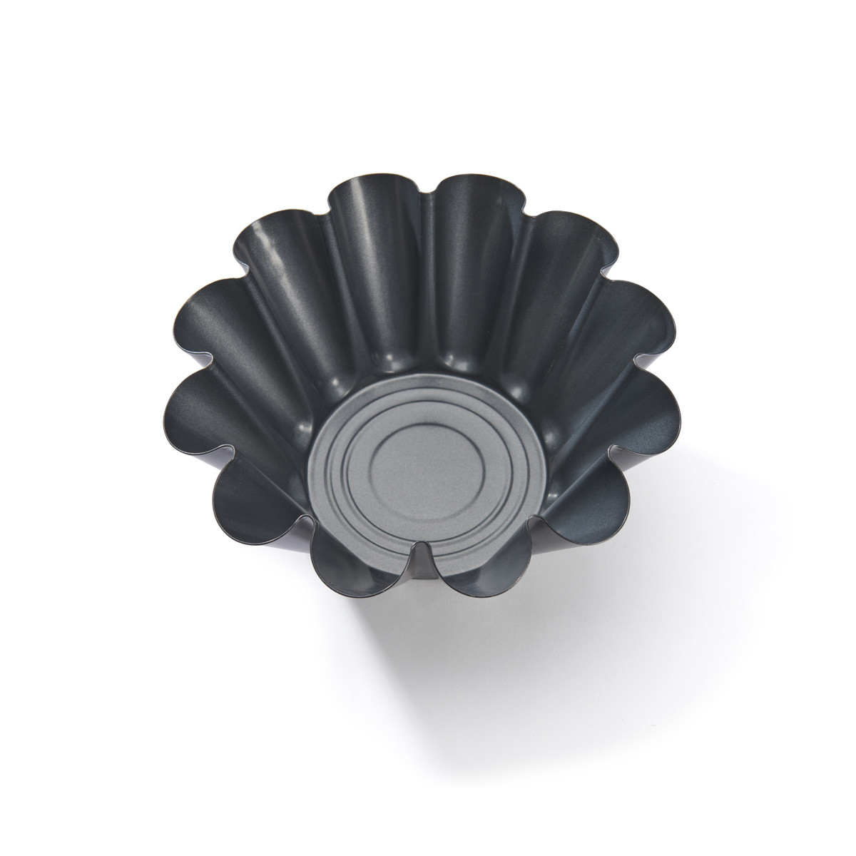 Moule à tarte gris foncé. Rond, avec un bord ondulé.