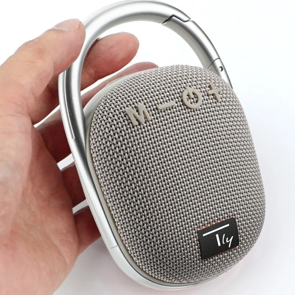 Grijze en witte speaker met karabijnhaak. Hand houdt speaker vast. Witte achtergrond.