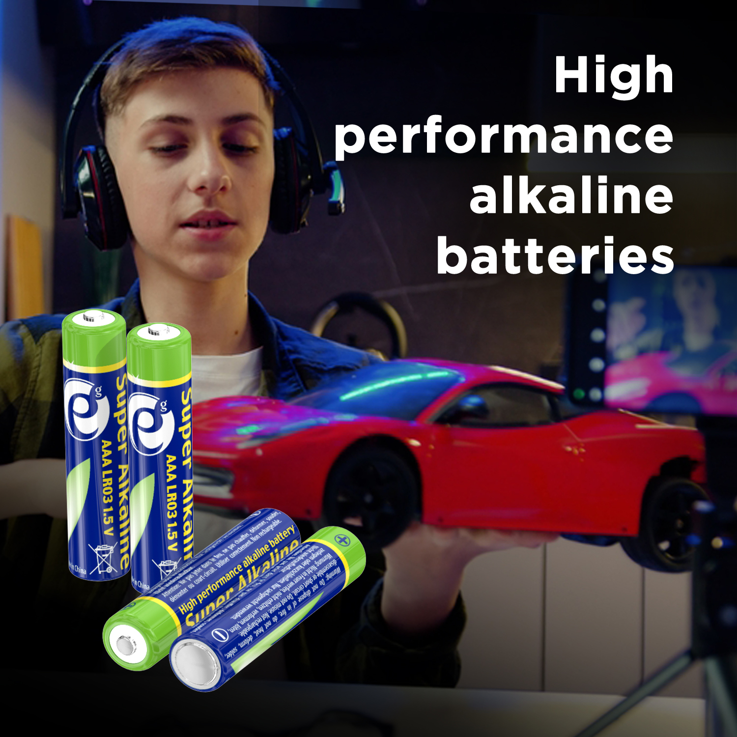 Een jonge man met een koptelefoon houdt een speelgoedauto vast. Drie Super Alkaline-batterijen op de voorgrond.