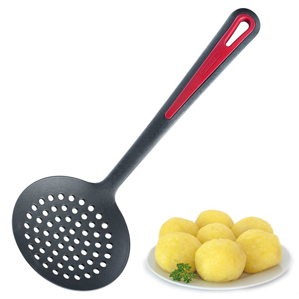 Cucchiaio nero scanalato con manico rosso, accanto a un piatto di gnocchi di patate. Sfondo bianco.