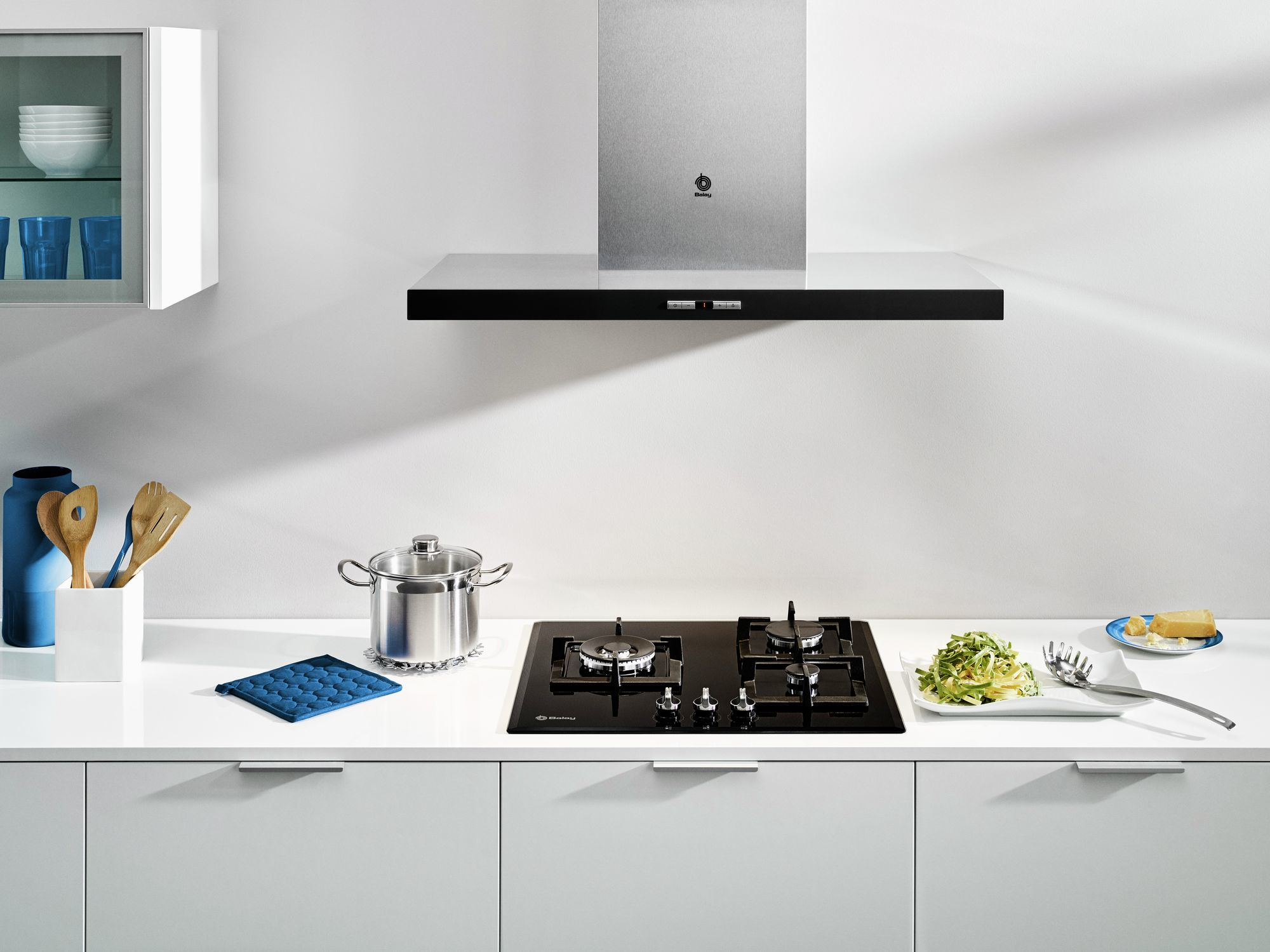 Escena de cocina con cocina, campana y encimera. Armarios blancos. Fondo blanco.