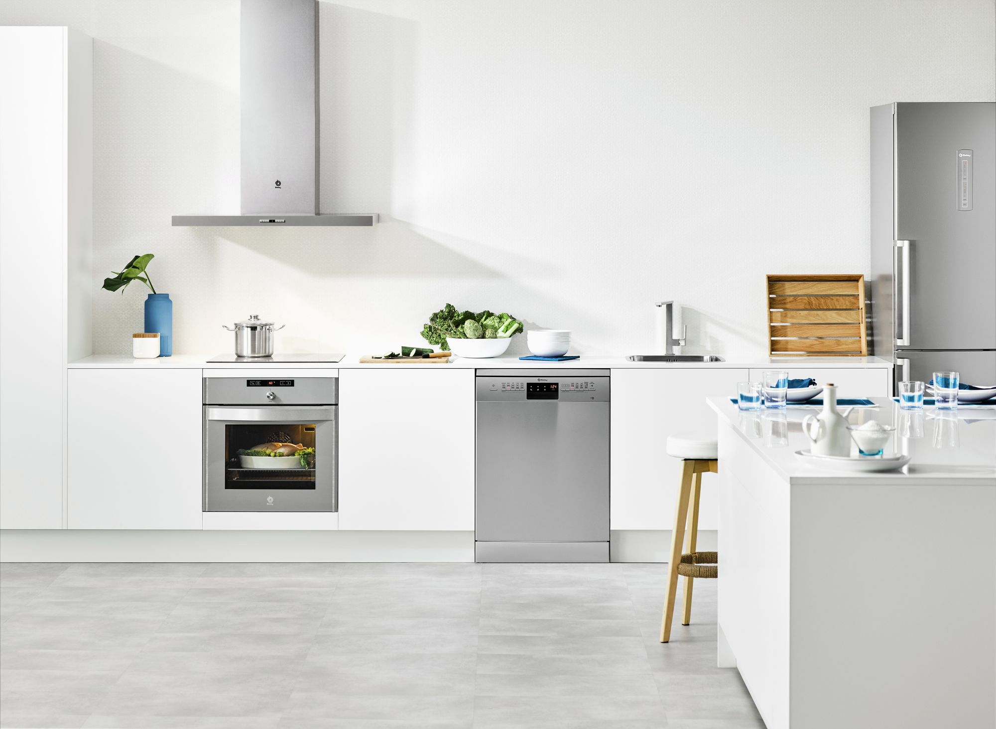 Escena de cocina con electrodomésticos, incluyendo horno, lavavajillas y refrigerador.