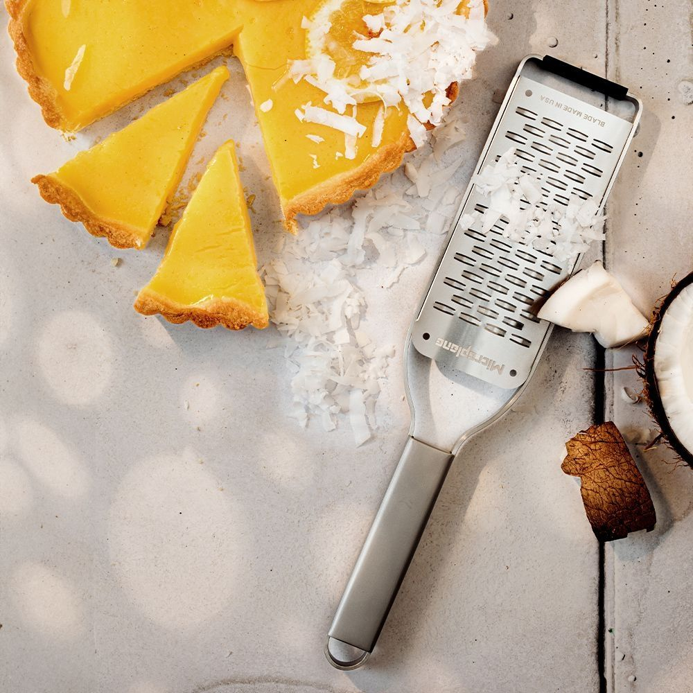 Crostata al limone con scaglie di cocco grattugiate con una grattugia Microplane.