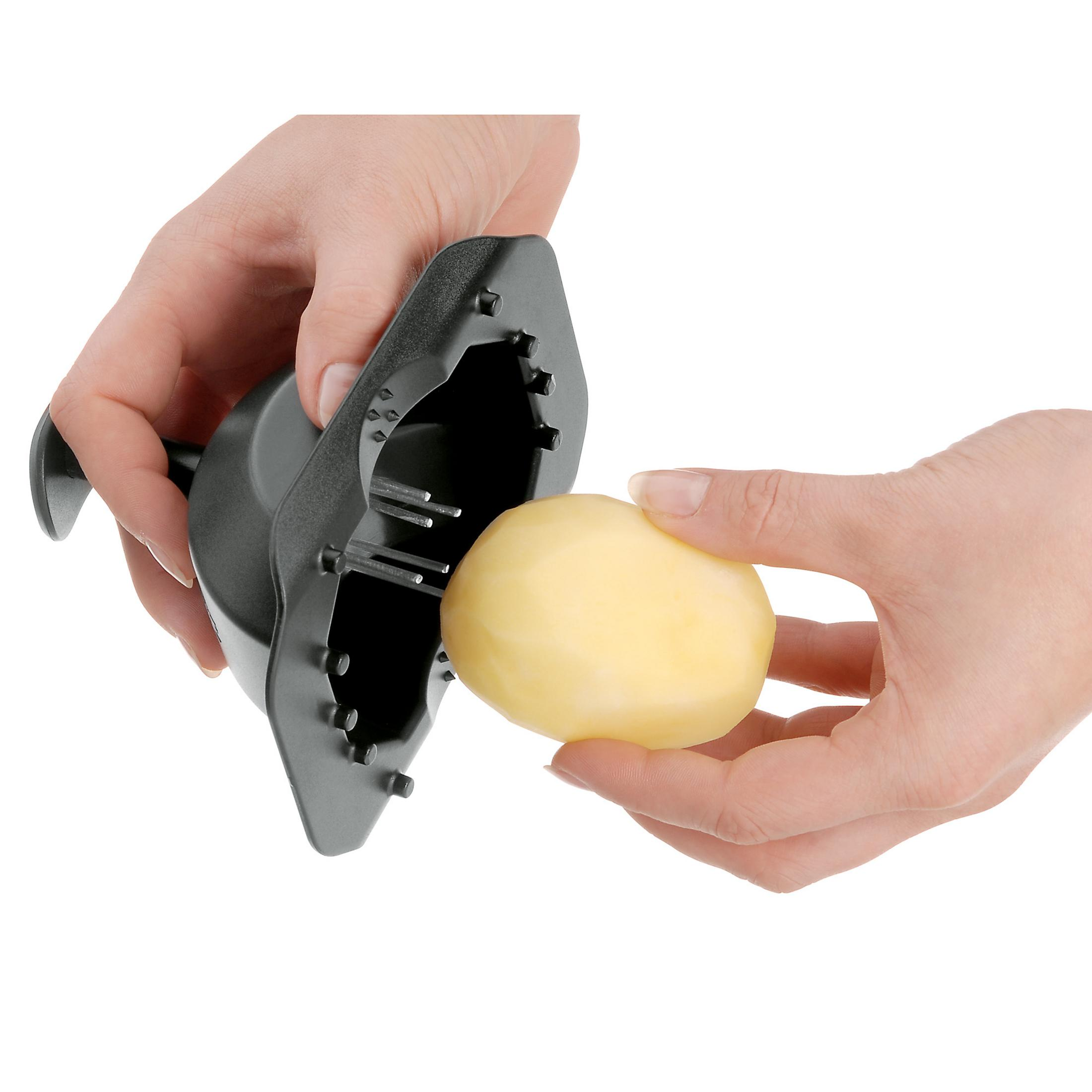 Dłonie trzymające ziemniaka z narzędziem kuchennym, gotowe do obierania.