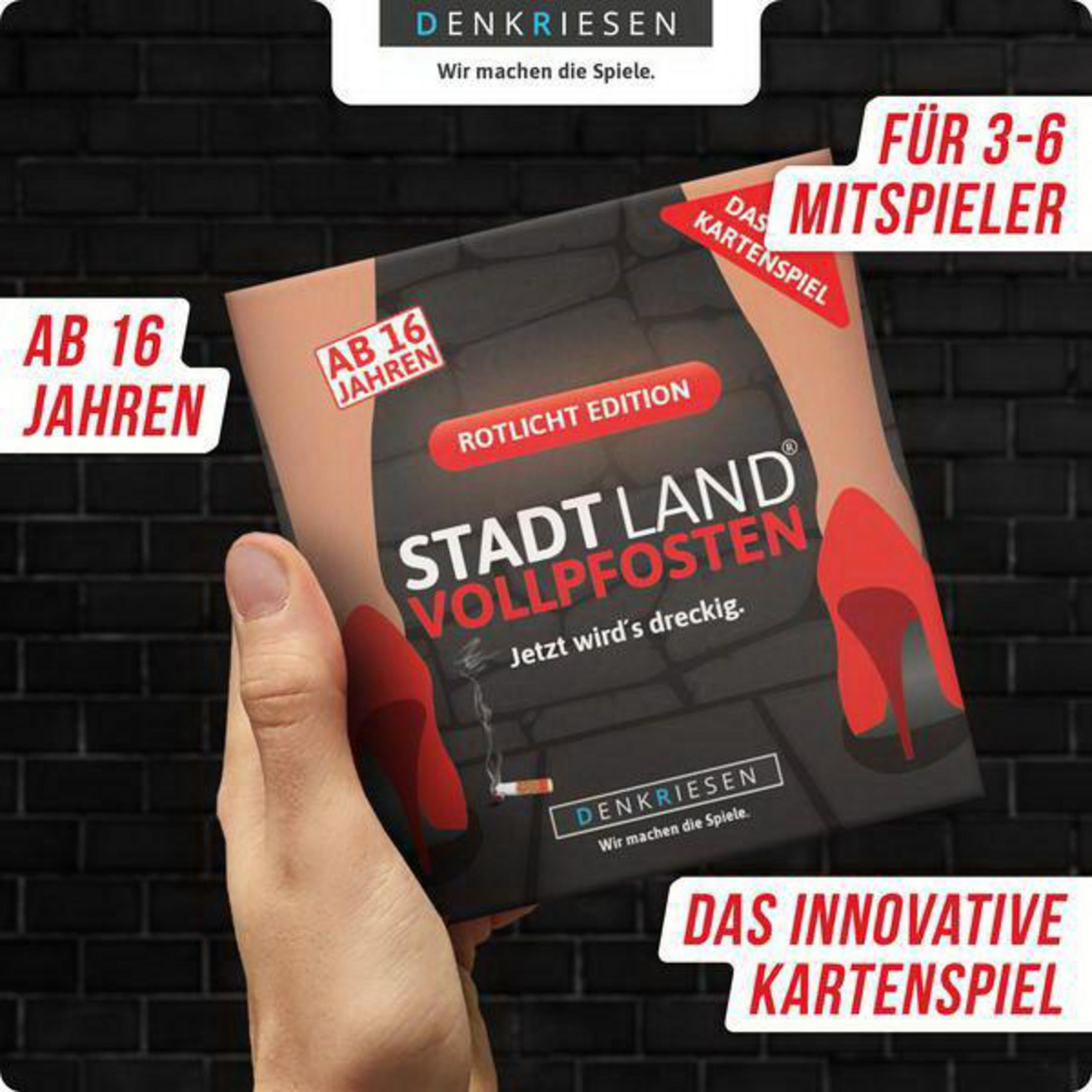 Hand hält eine Spielbox. Titel: Stadt Land Vollpfosten. Zigarette und rote High Heels sind abgebildet.