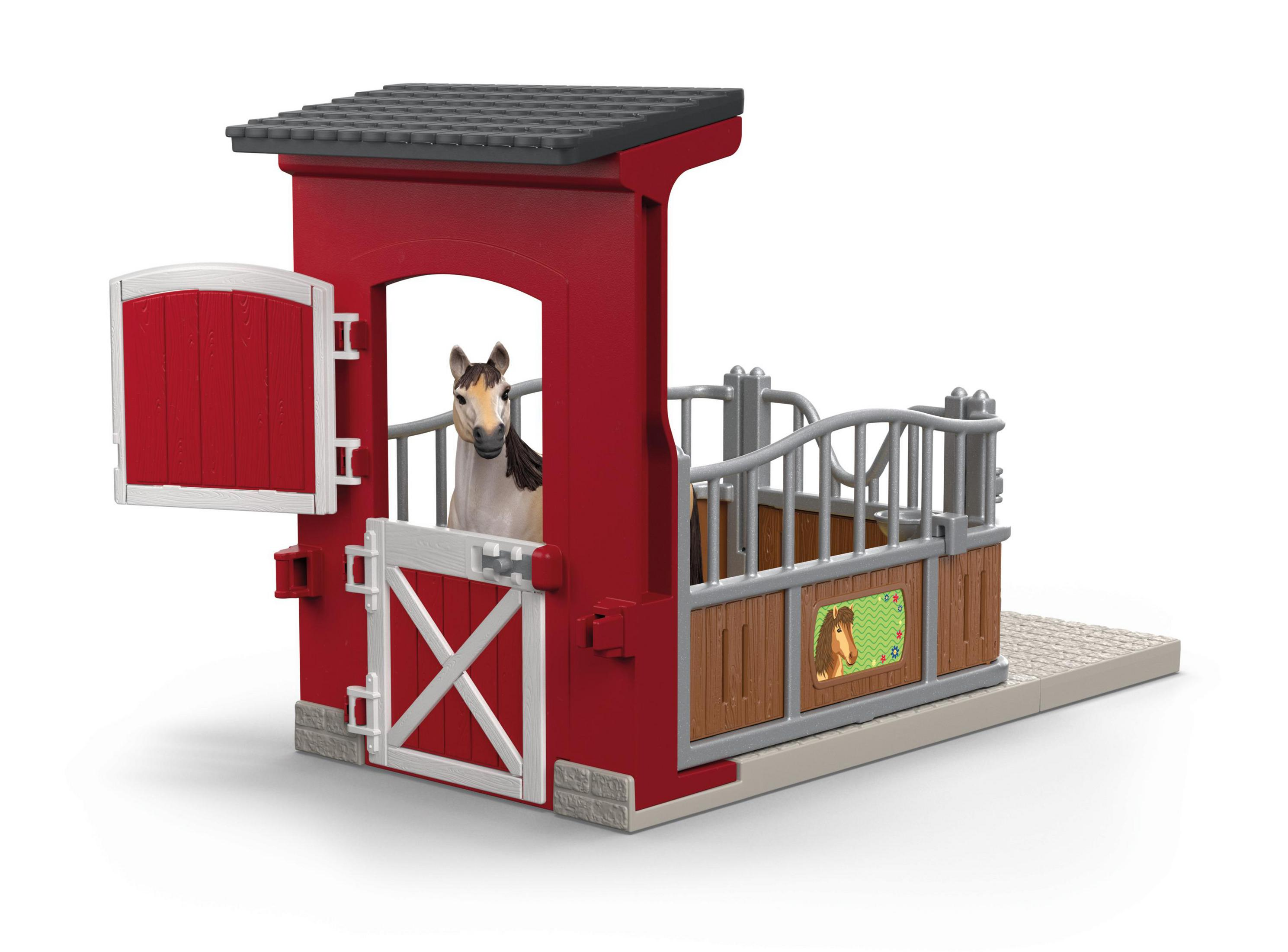 Cavallo giocattolo in una stalla rossa. Il cavallo è parzialmente visibile. Porta rossa.