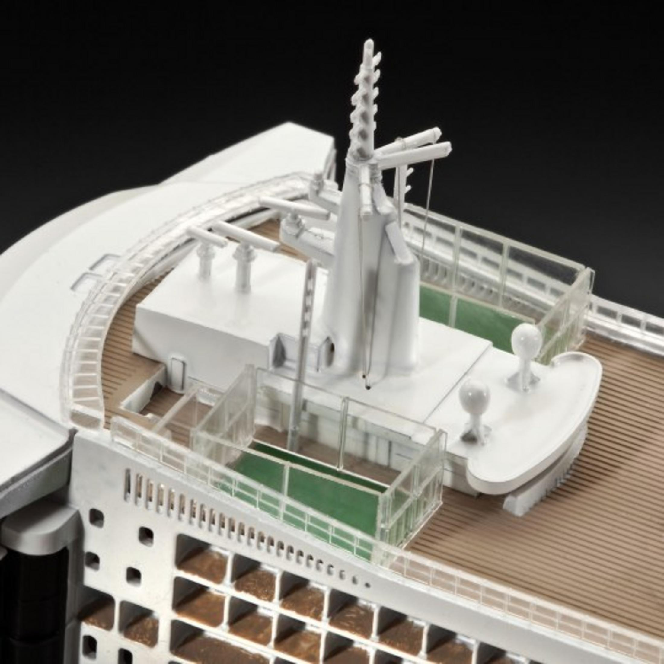 A white model ship, with a deck and various structures, on a black background.