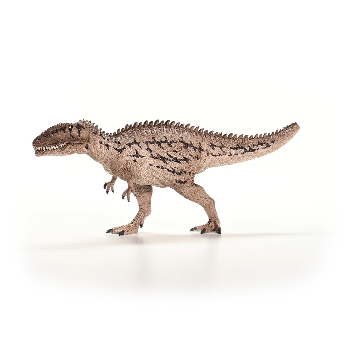 Juguete de dinosaurio sobre fondo blanco. Es marrón claro con manchas oscuras y está en posición de caminar.