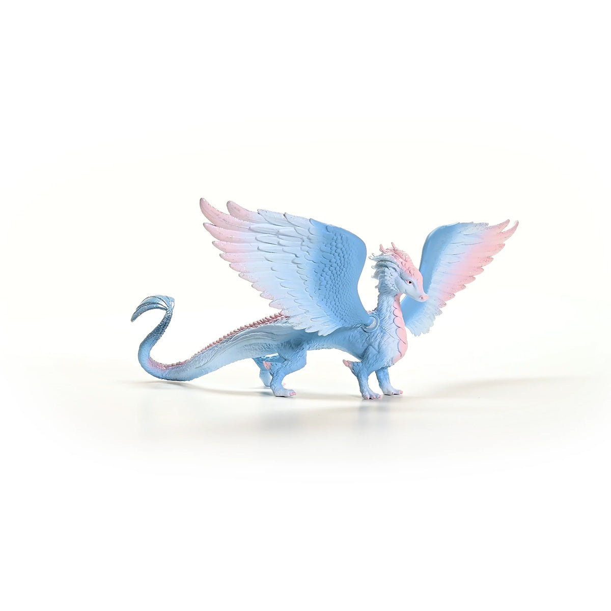 Un giocattolo a forma di drago blu e rosa con le ali spiegate, su sfondo bianco.