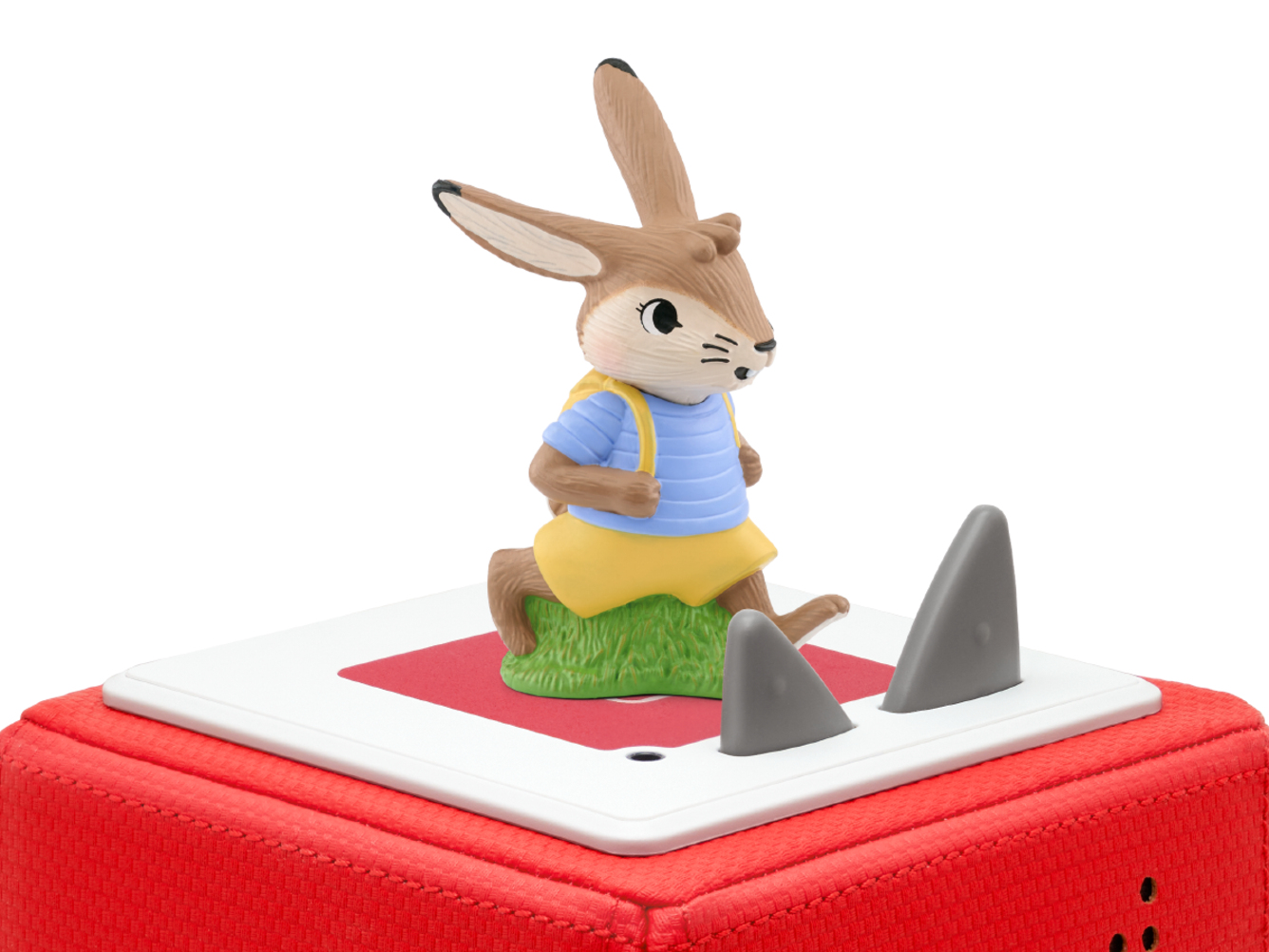 Zabawka królika z plecakiem na czerwonej podstawie z płetwami.