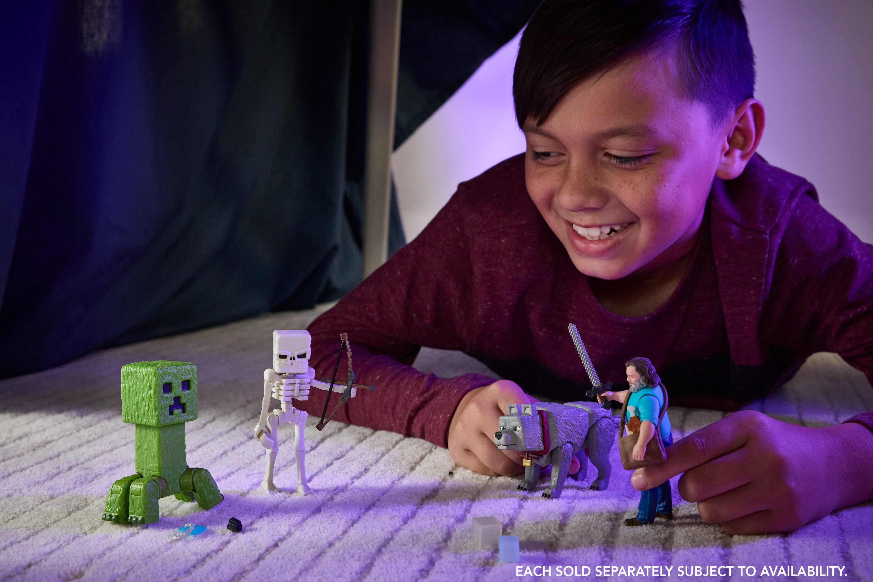 Un niño jugando con figuras de Minecraft, un creeper, esqueleto, lobo y Steve.