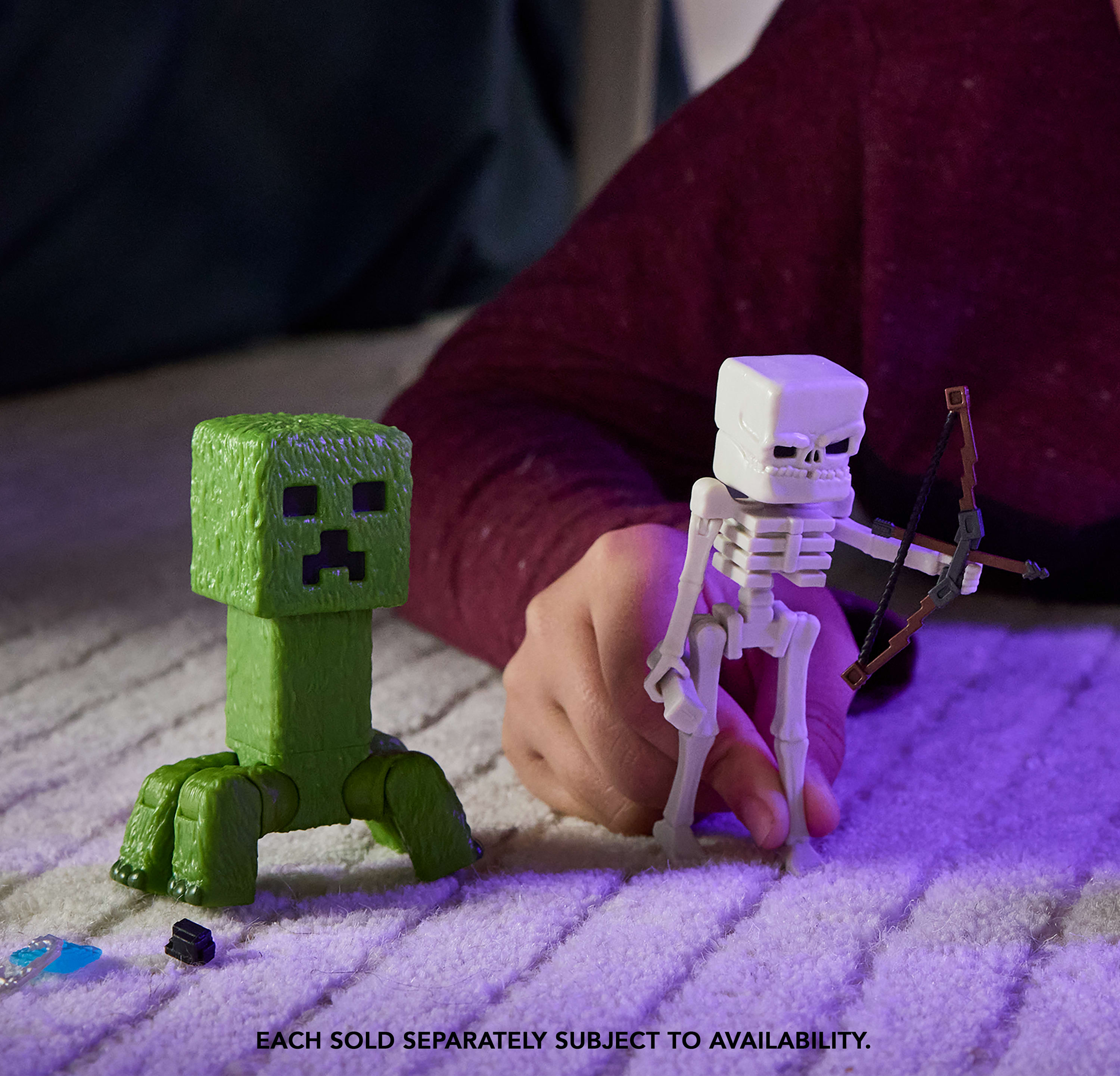 Primer plano de juguetes de Minecraft de un creeper verde y un esqueleto sobre una alfombra.