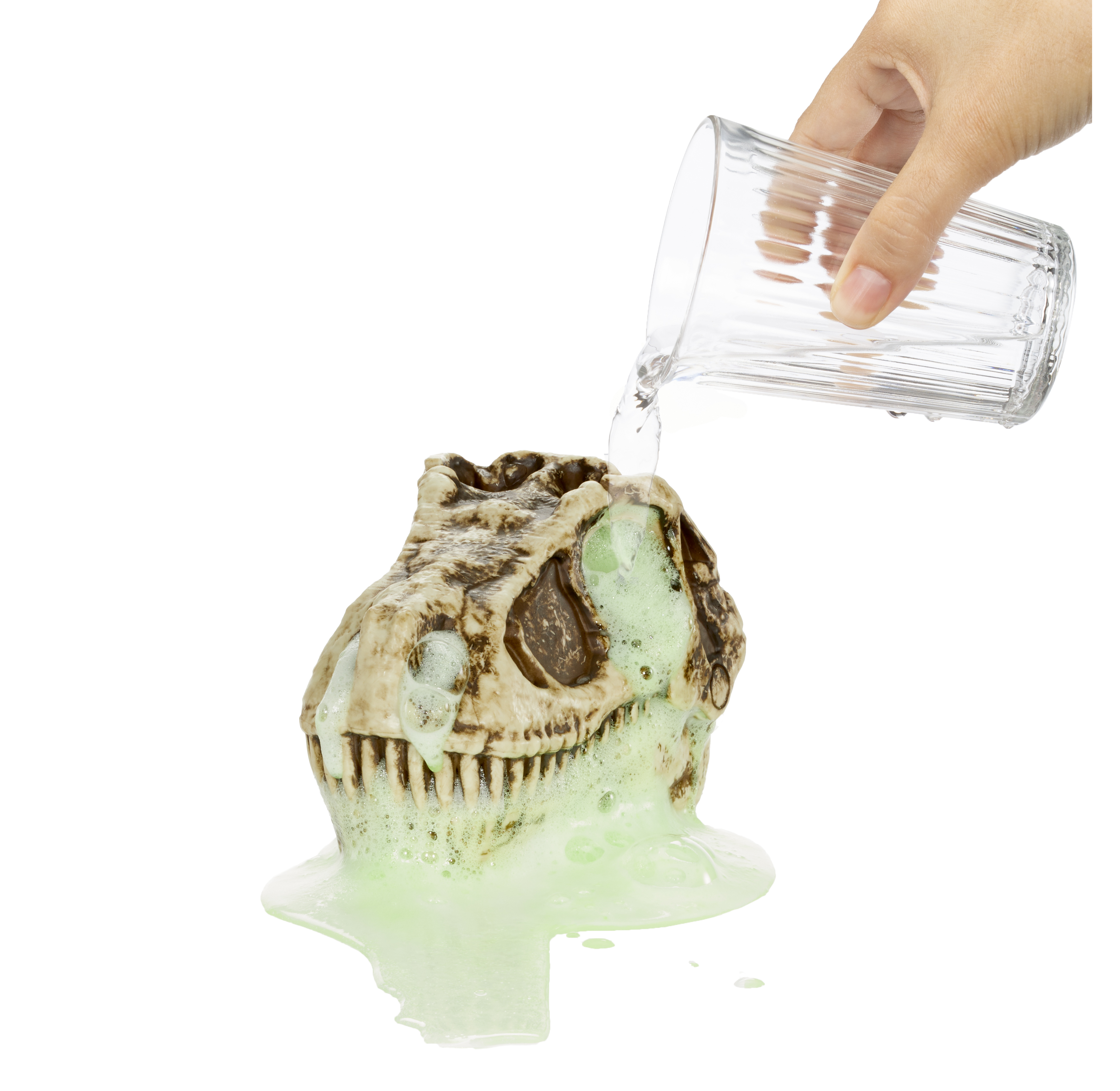 Una mano vertiendo agua sobre un juguete de cráneo de dinosaurio cubierto de limo verde.