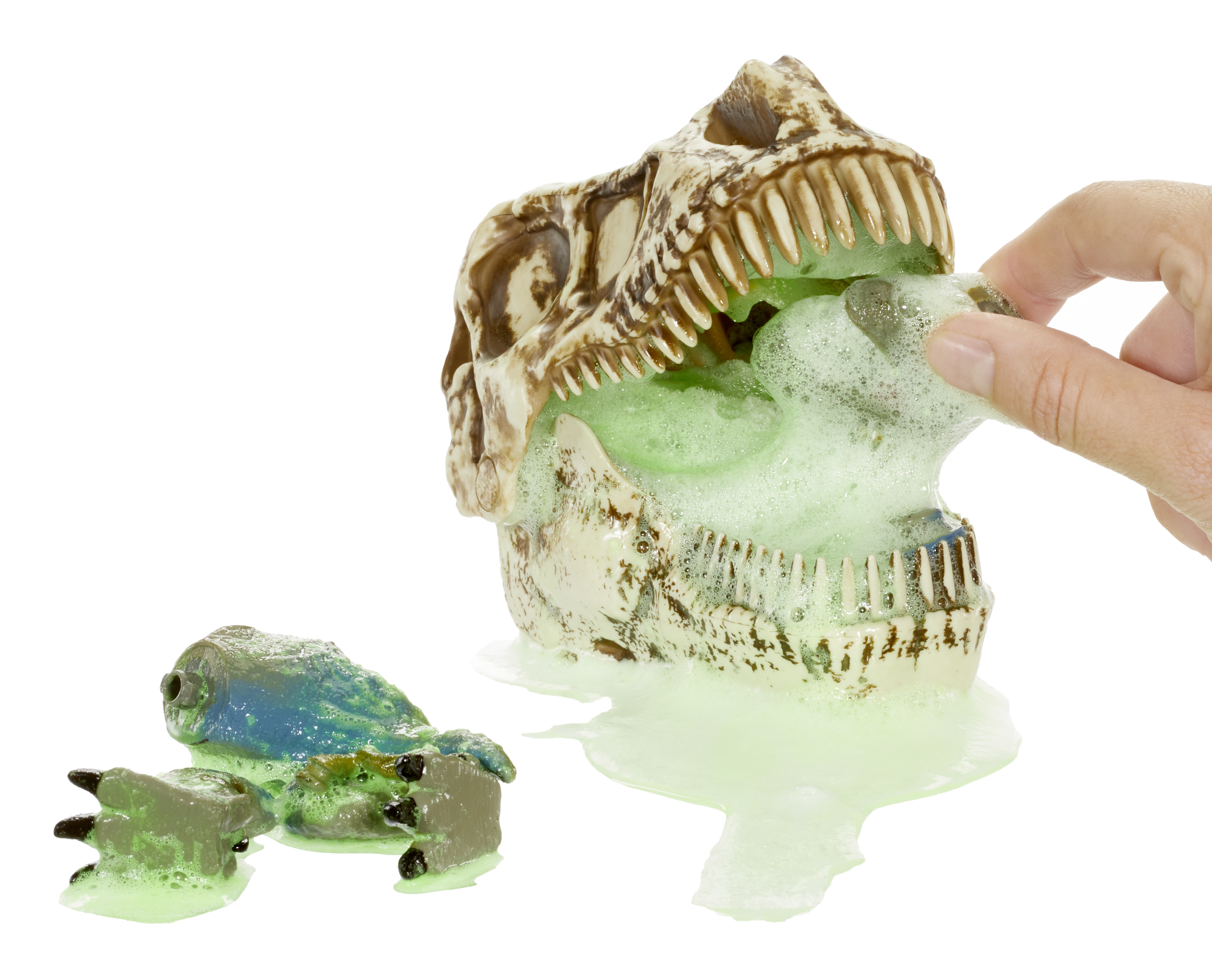 Cráneo de dinosaurio con espuma verde saliendo. Una mano está dentro.