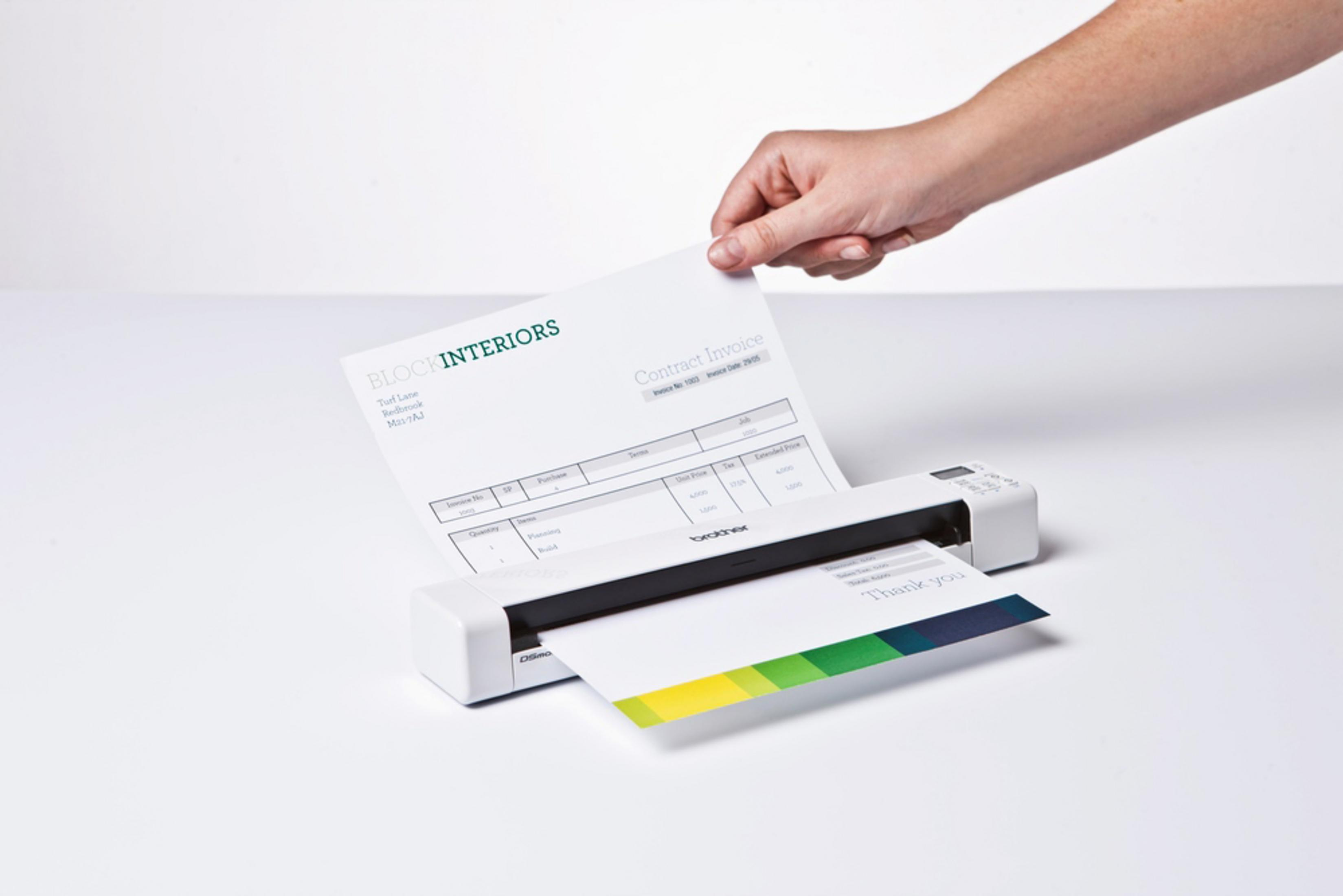 Mano che inserisce un foglio in uno scanner per documenti Brother.