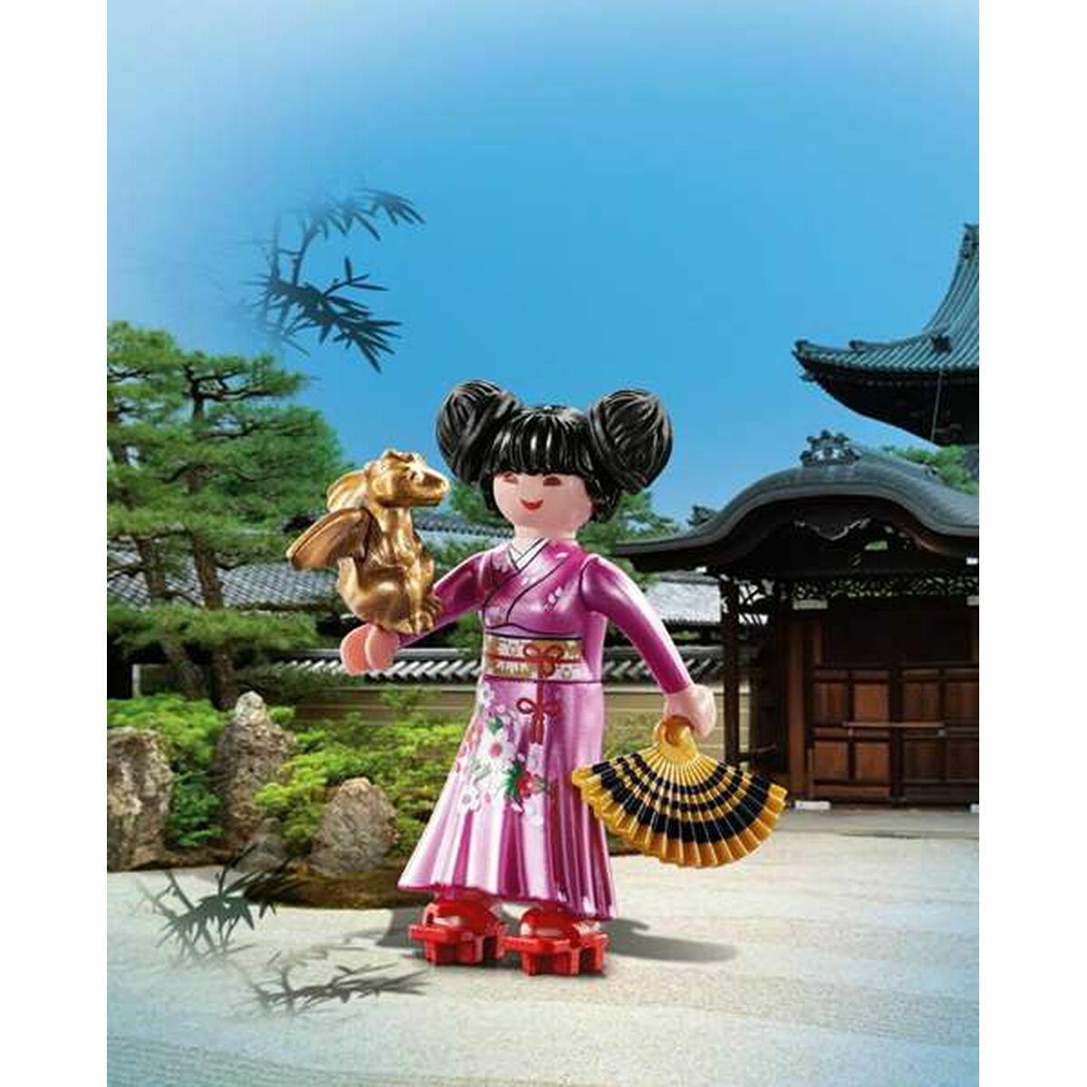 Figurka Playmobil w kimono trzymająca wachlarz i złotą statuetkę, tło z świątynią.