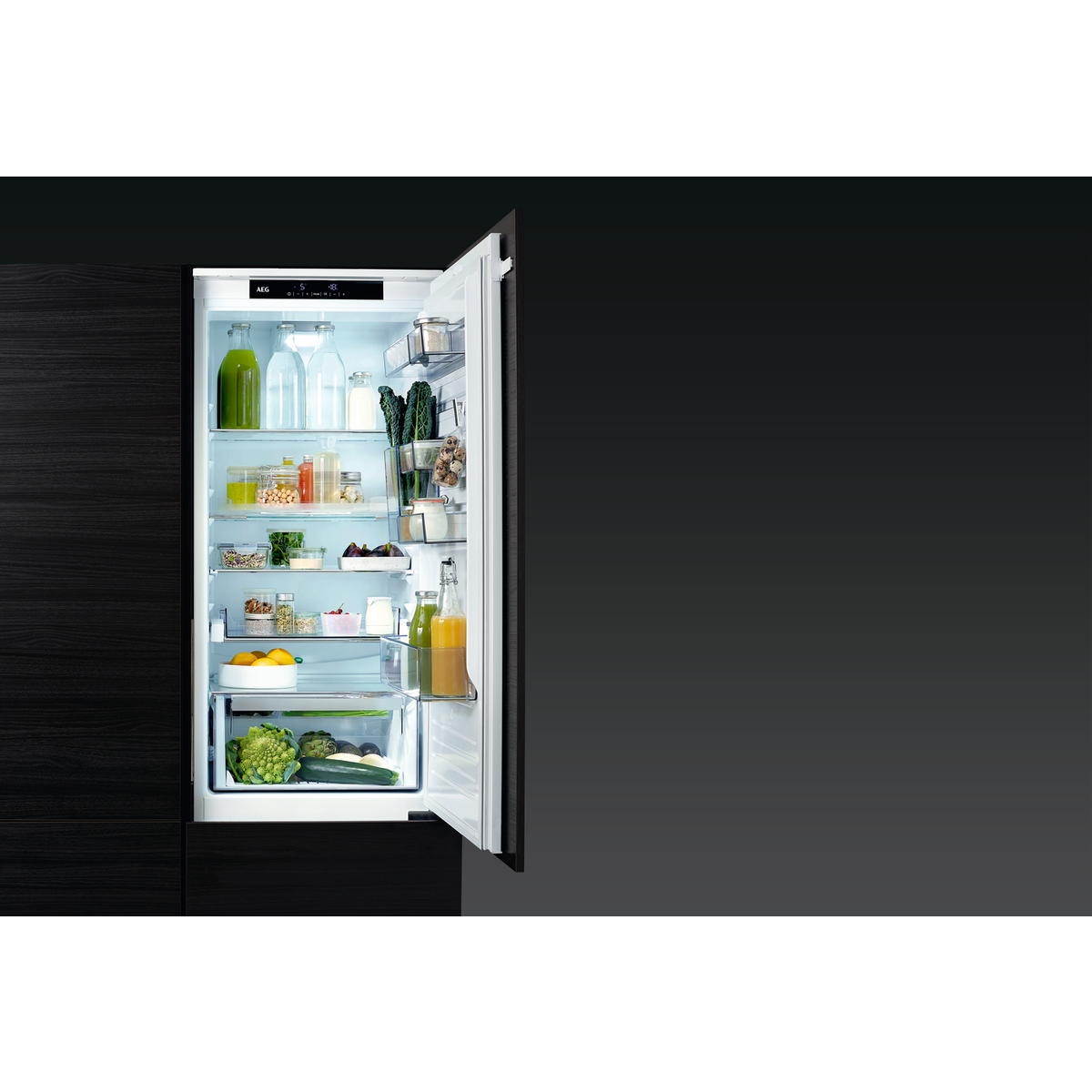 Lodówka z otwartymi drzwiami, pokazująca półki z jedzeniem i napojami.