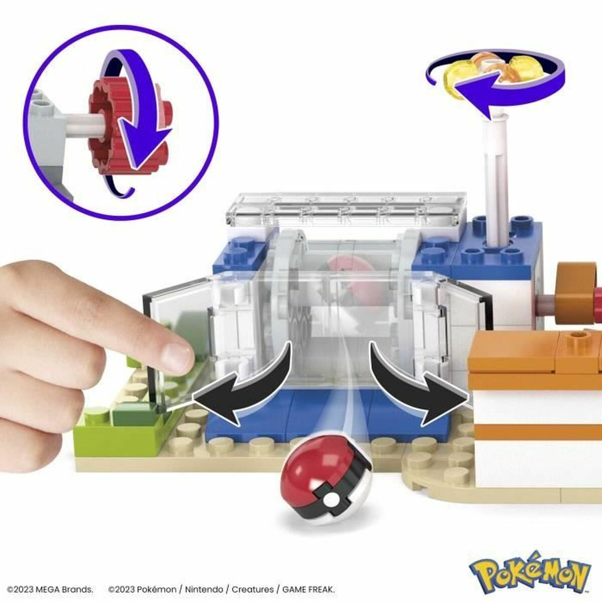 Mano di un bambino che aziona un giocattolo Pokémon. Pokéball rossa e bianca in primo piano, con blocchi.