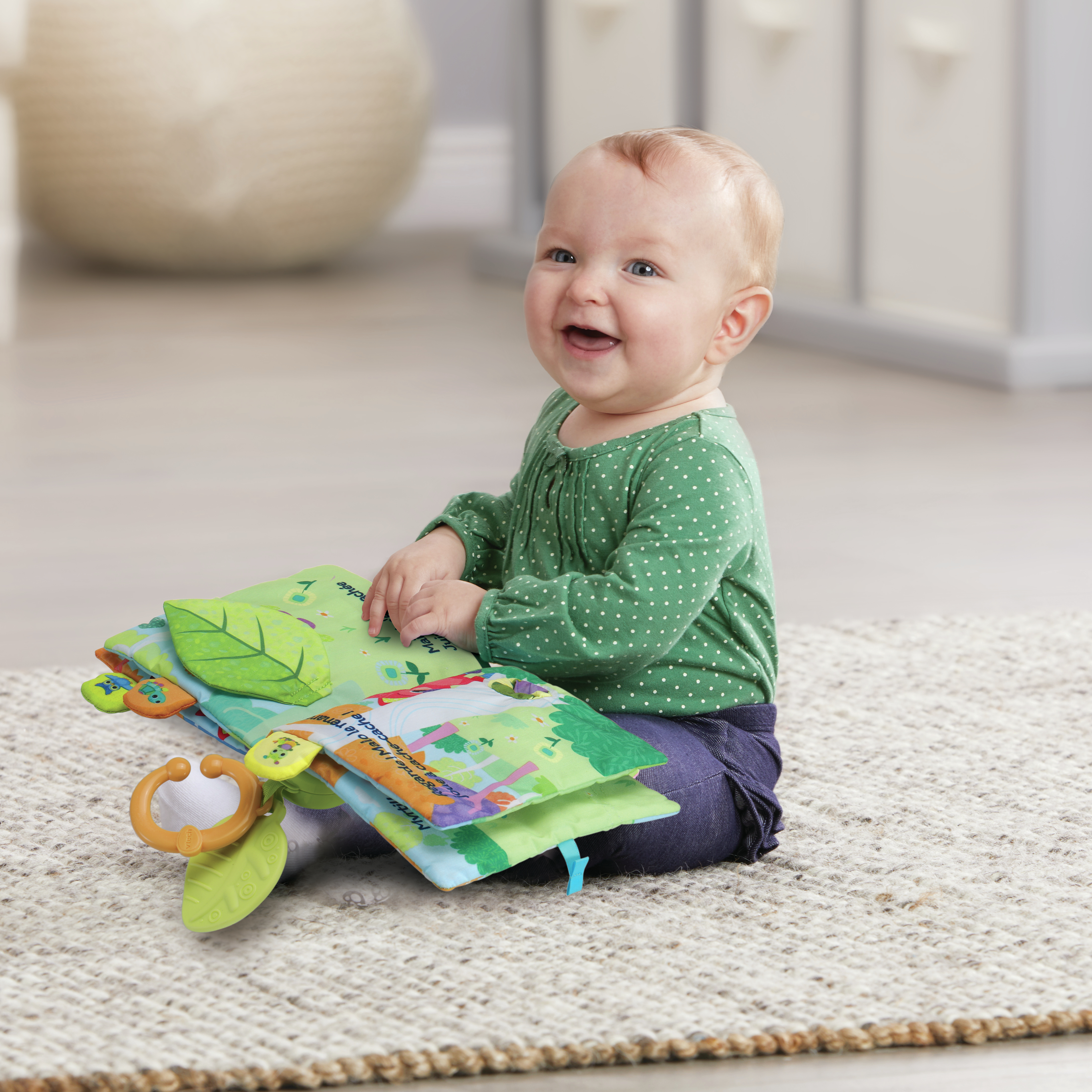 Dziecko uśmiecha się, siedząc na dywanie i patrząc na kolorową książkę.