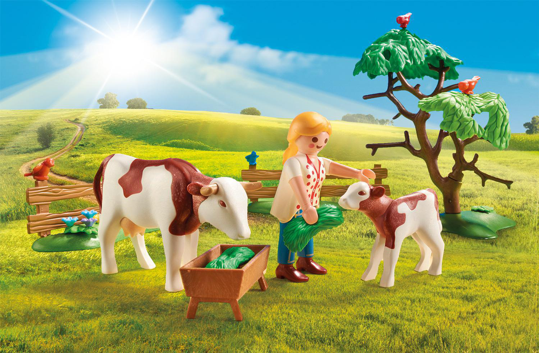 Scena della fattoria Playmobil con mucca, vitello, donna e albero. Campo soleggiato e verde.
