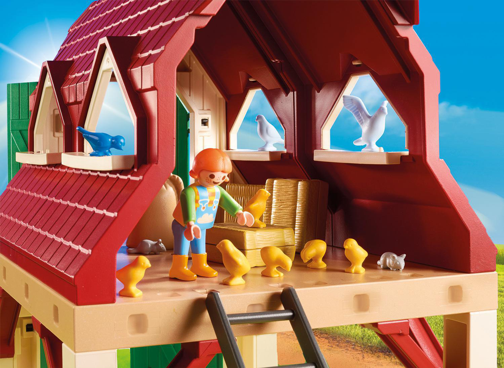 Set fattoria Playmobil con fienile, figura e pulcini. Cielo blu e campo verde.