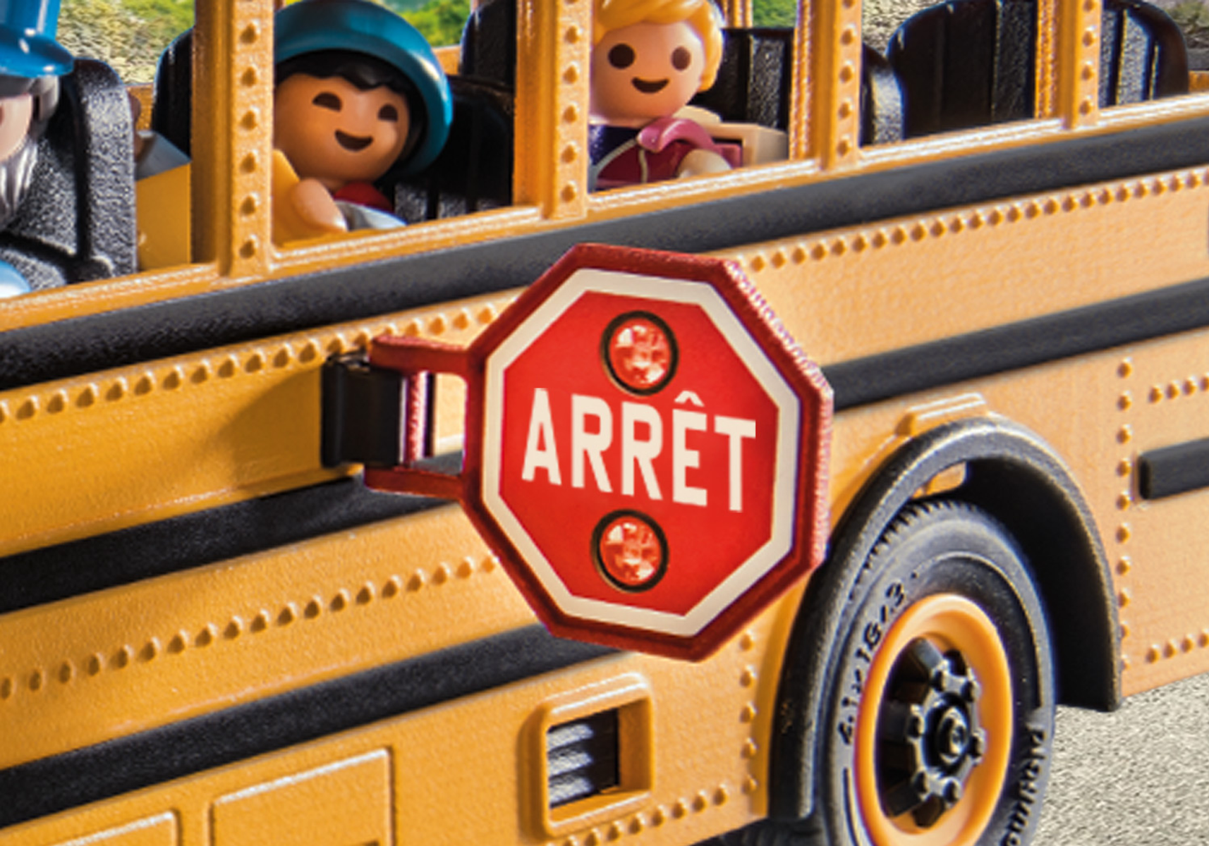Zbliżenie żółtego autobusu szkolnego z rozłożonym czerwonym znakiem 'ARRÊT'. W środku widoczne dzieci.