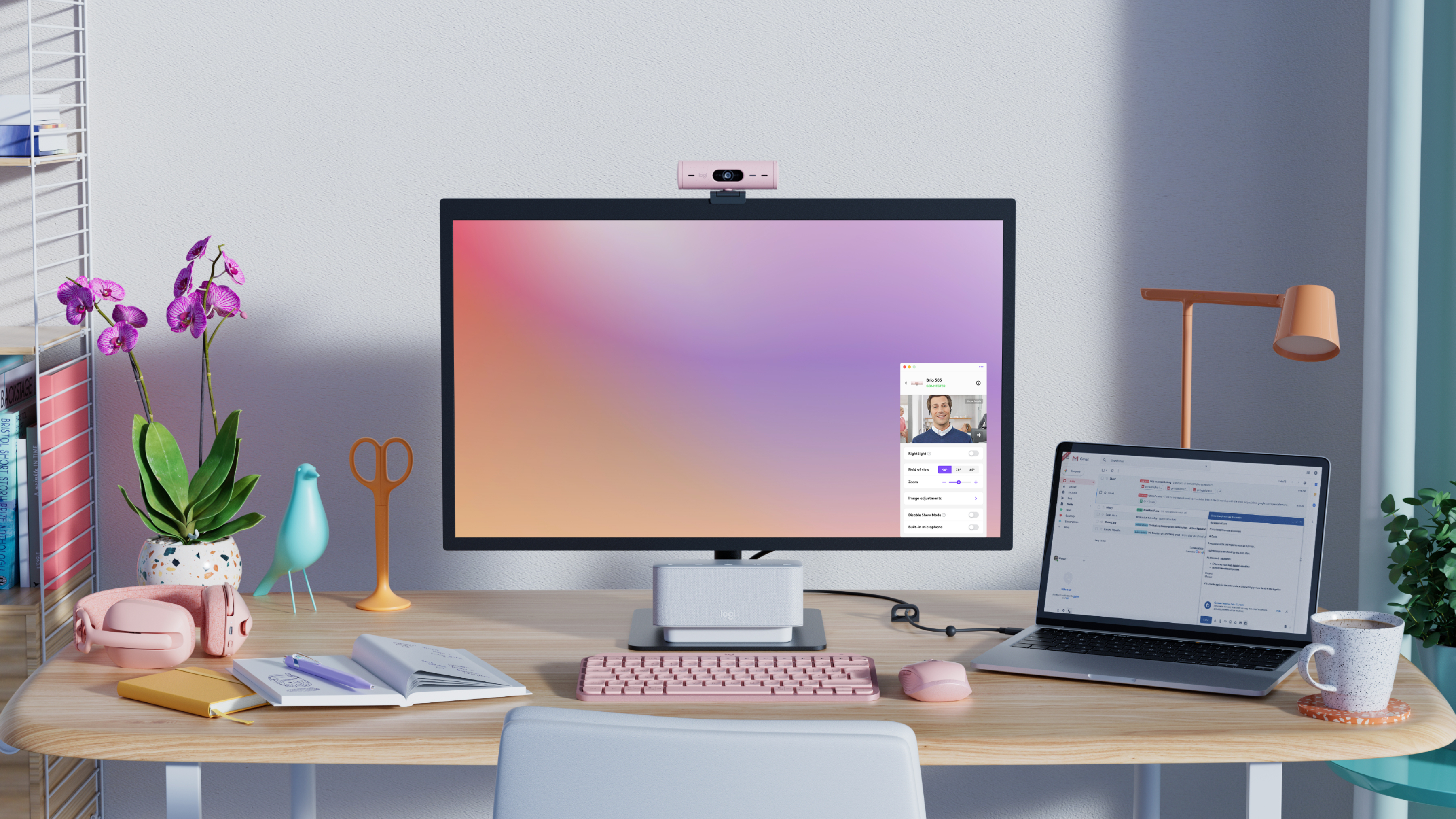 Biurko z monitorem pokazującym rozmowę wideo, kamerą internetową i laptopem.