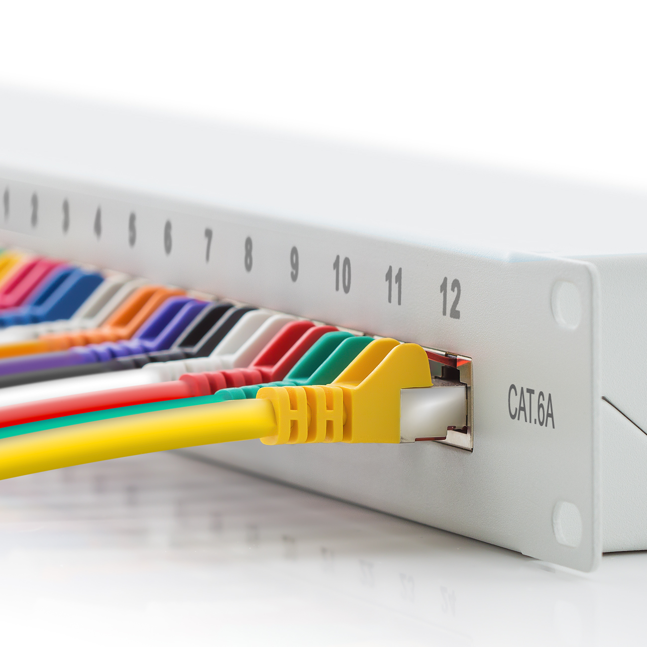 Ein CAT.6A-Patchfeld mit eingesteckten Ethernet-Kabeln. Die Kabel sind in verschiedenen Farben.