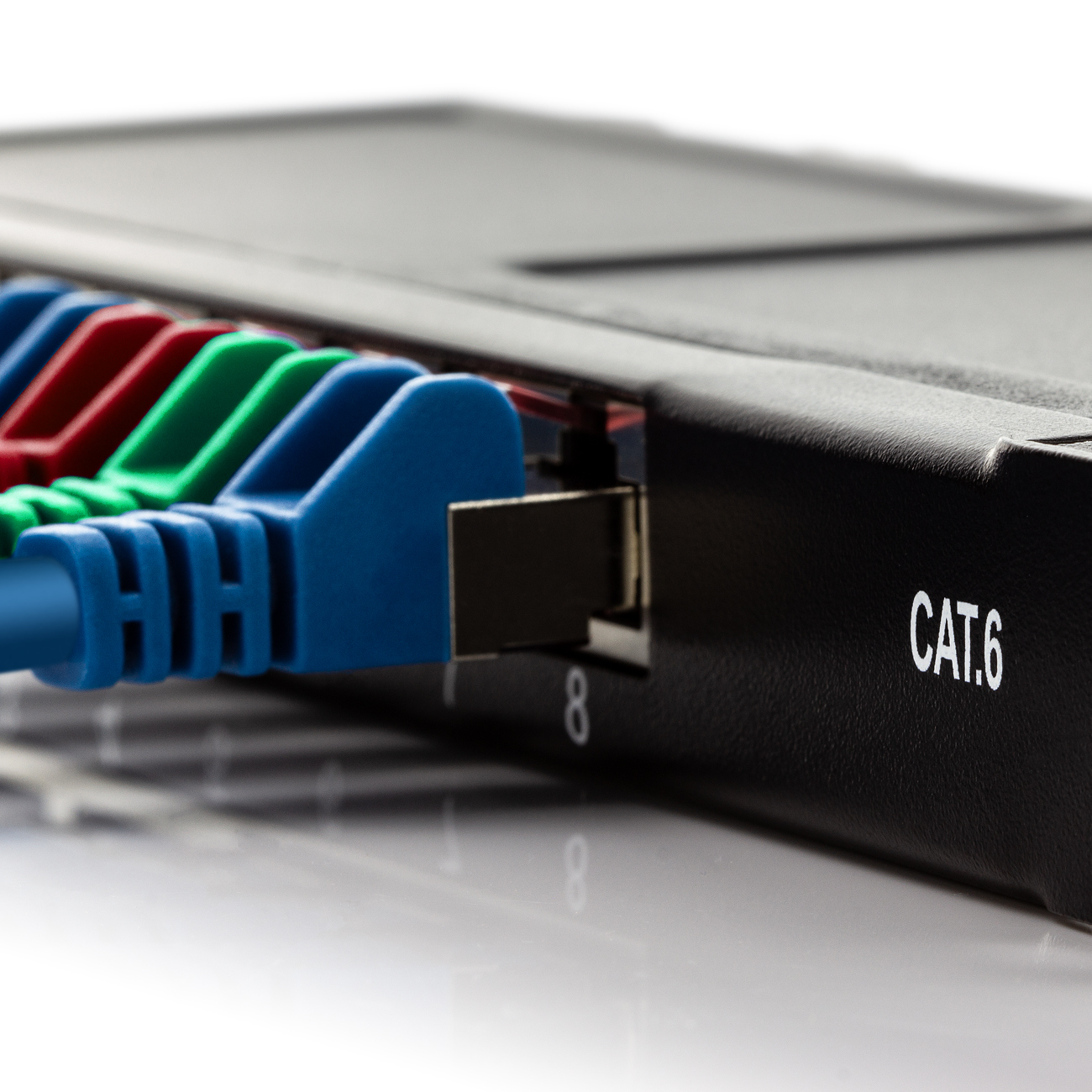 Primo piano di uno switch di rete nero con cavi di rete colorati collegati.