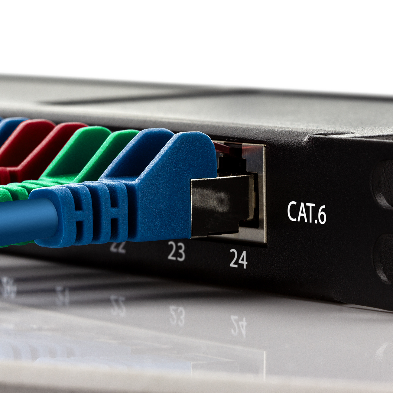 Nahaufnahme eines Netzwerk-Patchpanels mit CAT.6-Kabeln. Blaue, grüne und rote Kabel.