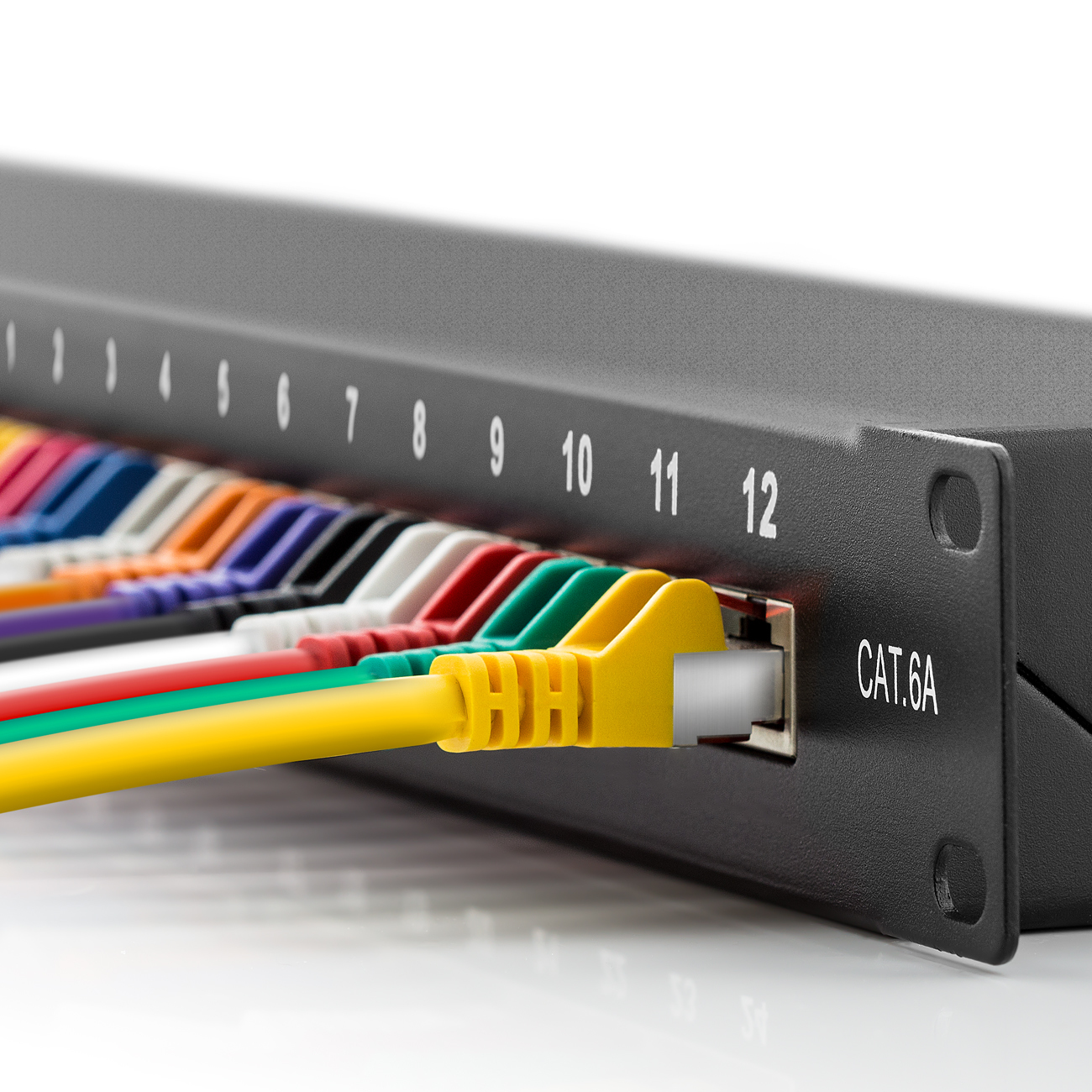 Nahaufnahme eines schwarzen Patchpanels mit nummerierten Anschlüssen und bunten eingesteckten Kabeln. Weißer Hintergrund.