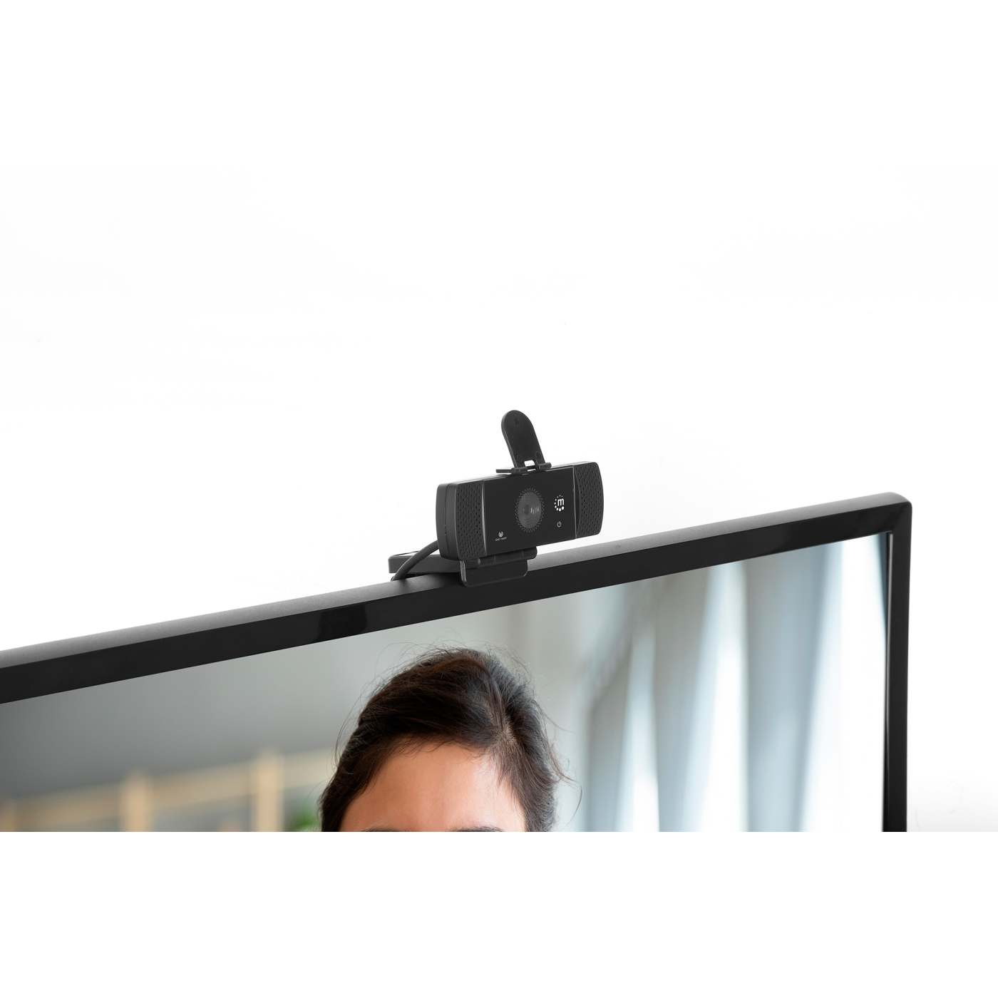 Webcam su un monitor. La fotocamera è nera, con lo schermo che mostra il volto di una persona.