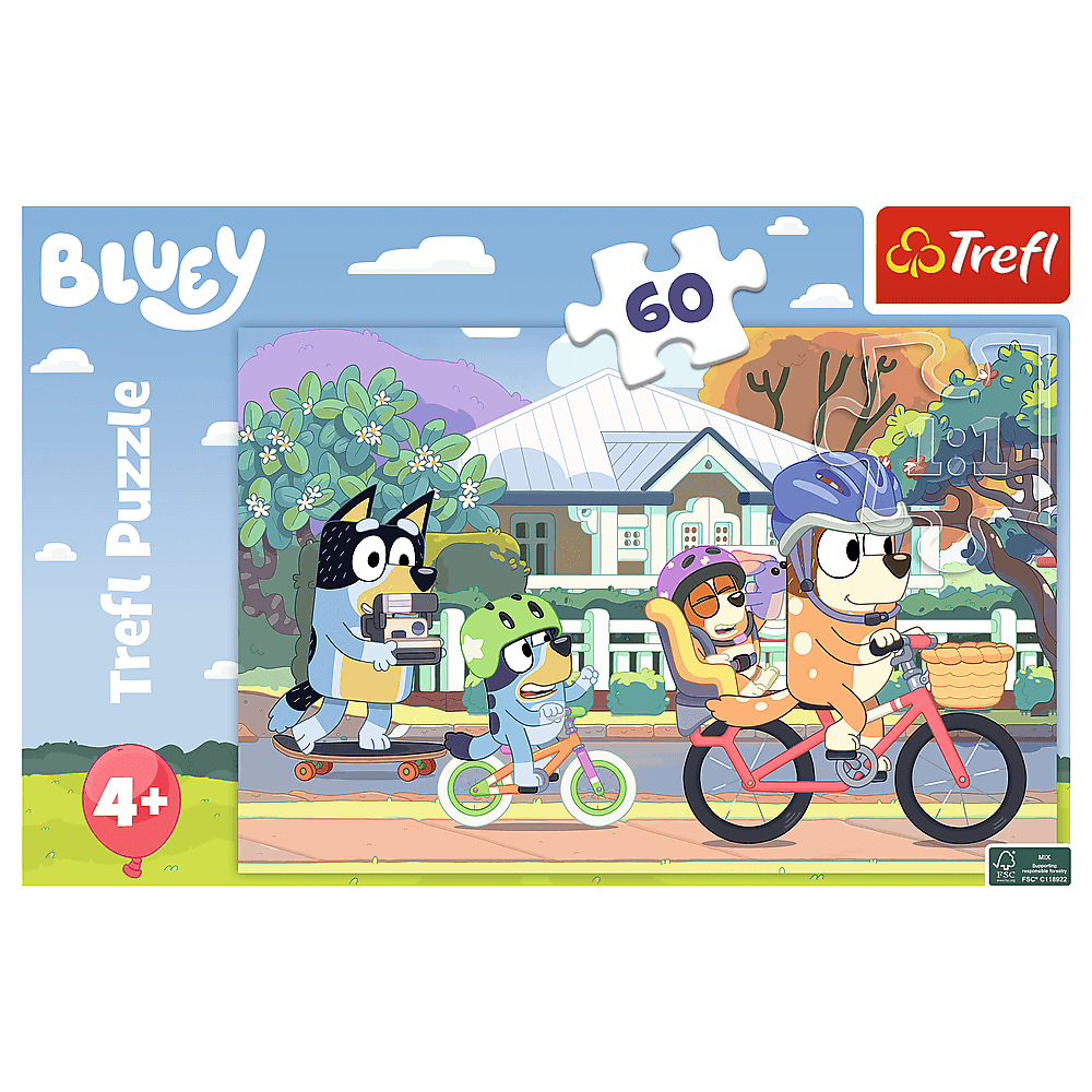 Une boîte de puzzle Bluey montrant une famille de chiens à vélo et un skateboard, dans un cadre de quartier.