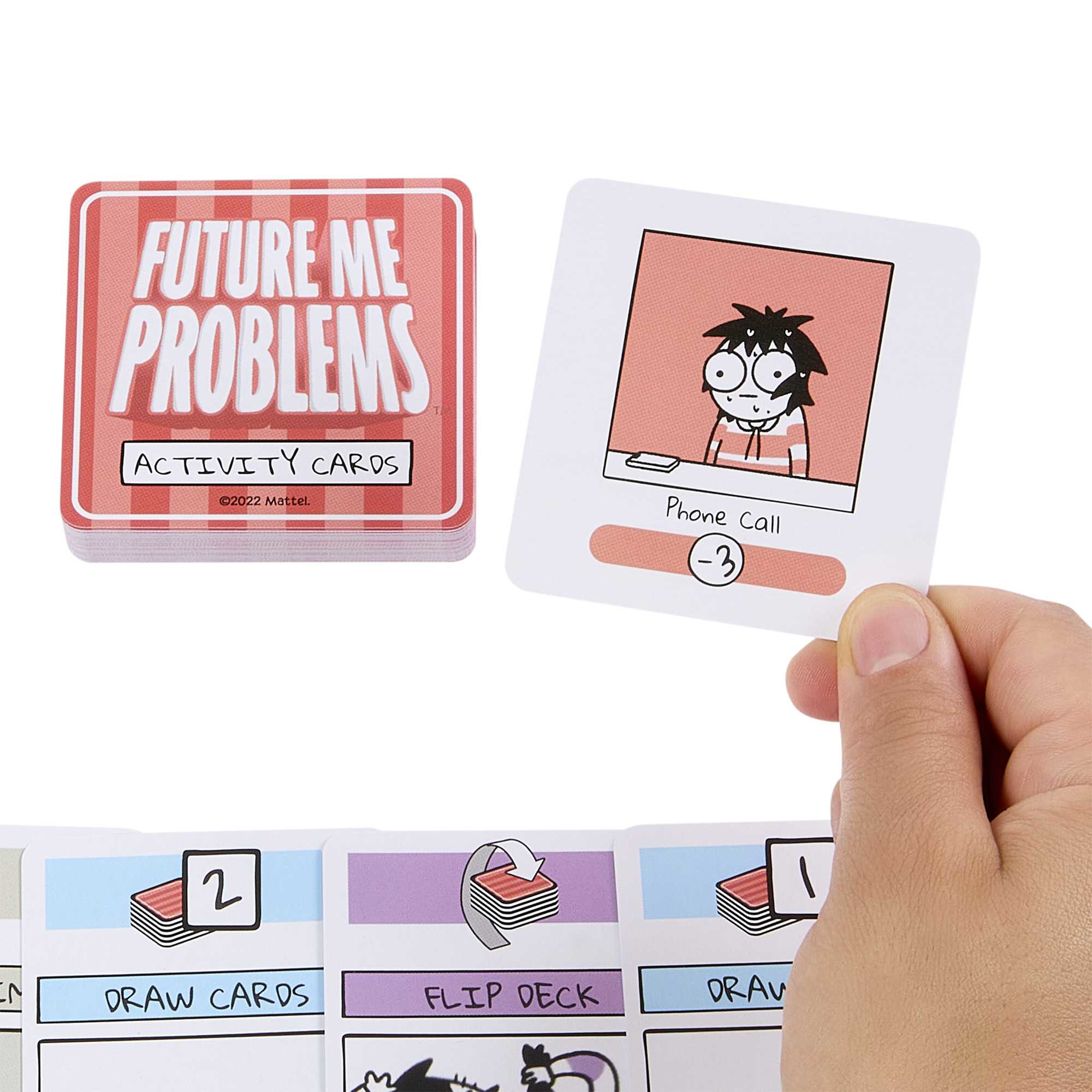 Eine Hand hält eine Karte aus dem Spiel 'Future Me Problems', neben anderen Karten und der Spielbox.