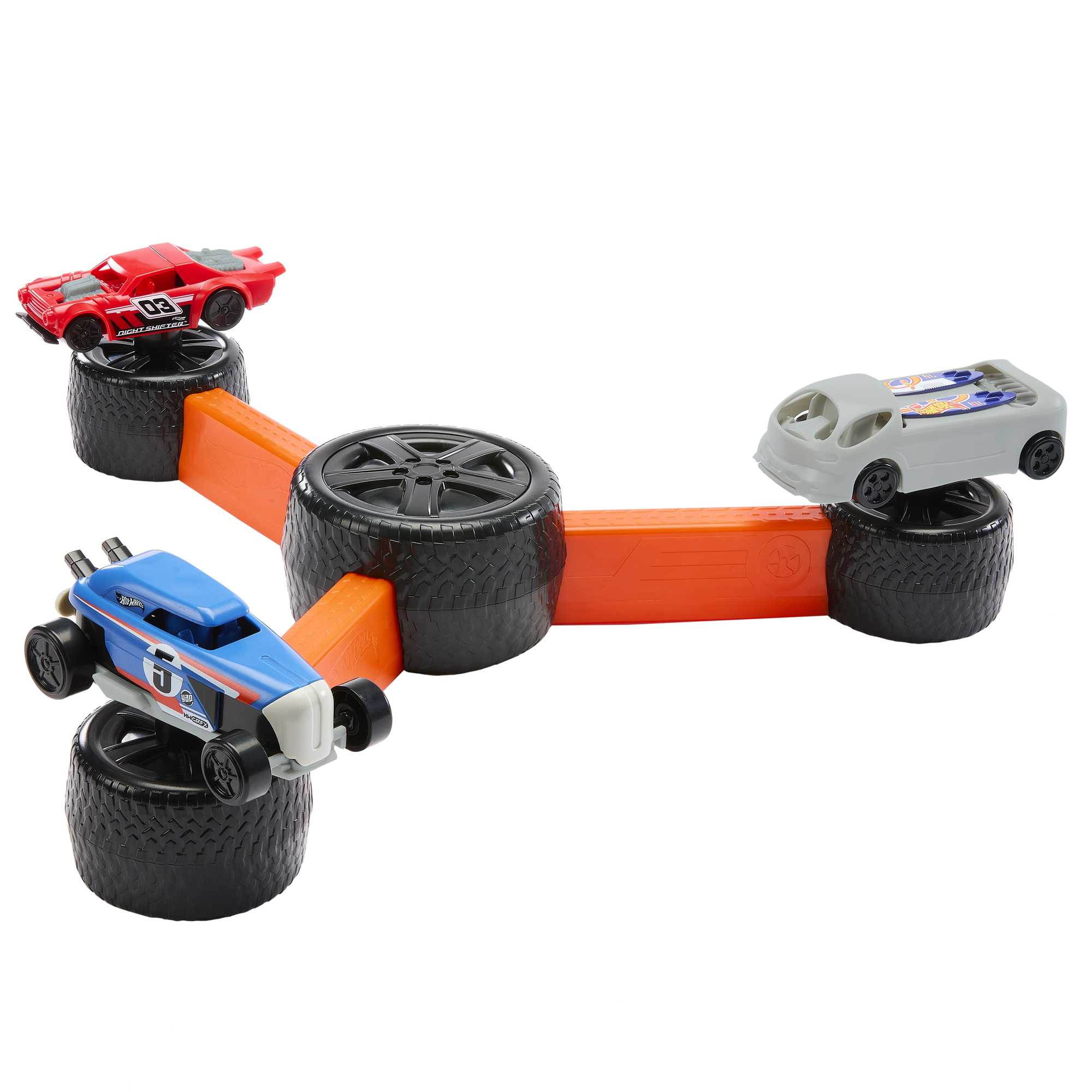 Pista de carreras de juguete con tres coches Hot Wheels de diferentes colores, sobre neumáticos negros y pista naranja.