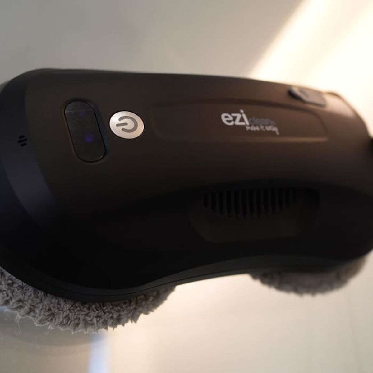 Czarny czyścik do okien z logo ezi clean, na białej powierzchni.