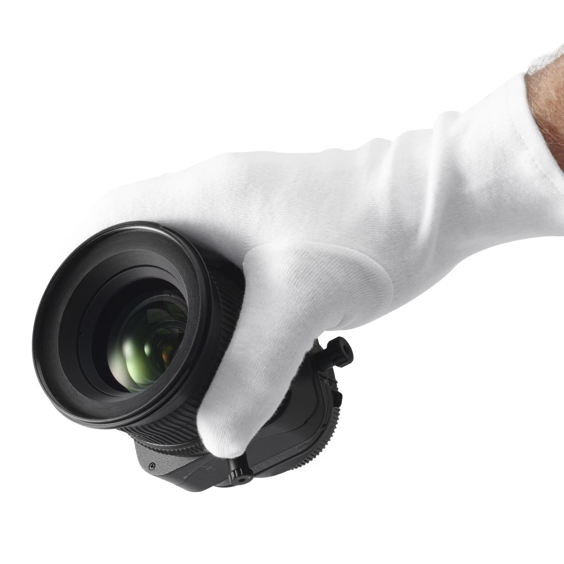 Una mano con un guanto bianco tiene un obiettivo nero con riflessi verdi.