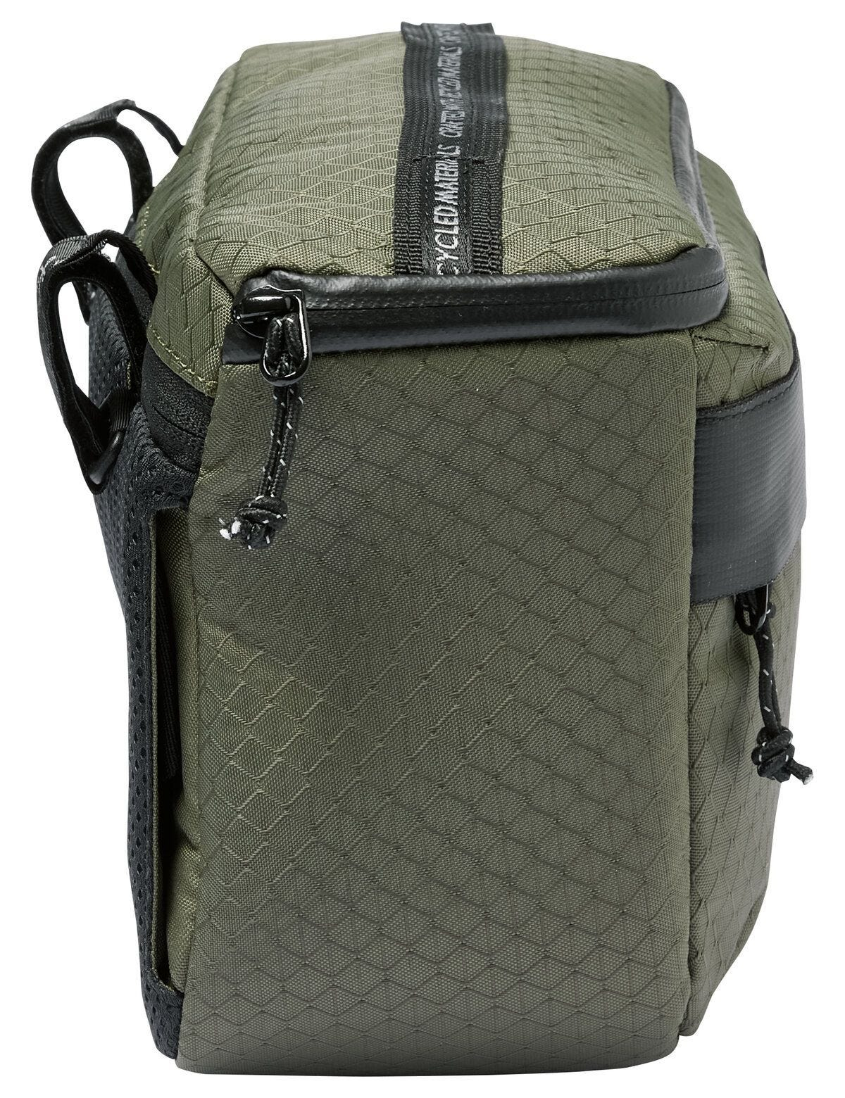 Zielona torba rowerowa, widok z boku, z czarnymi paskami i zamkami błyskawicznymi.