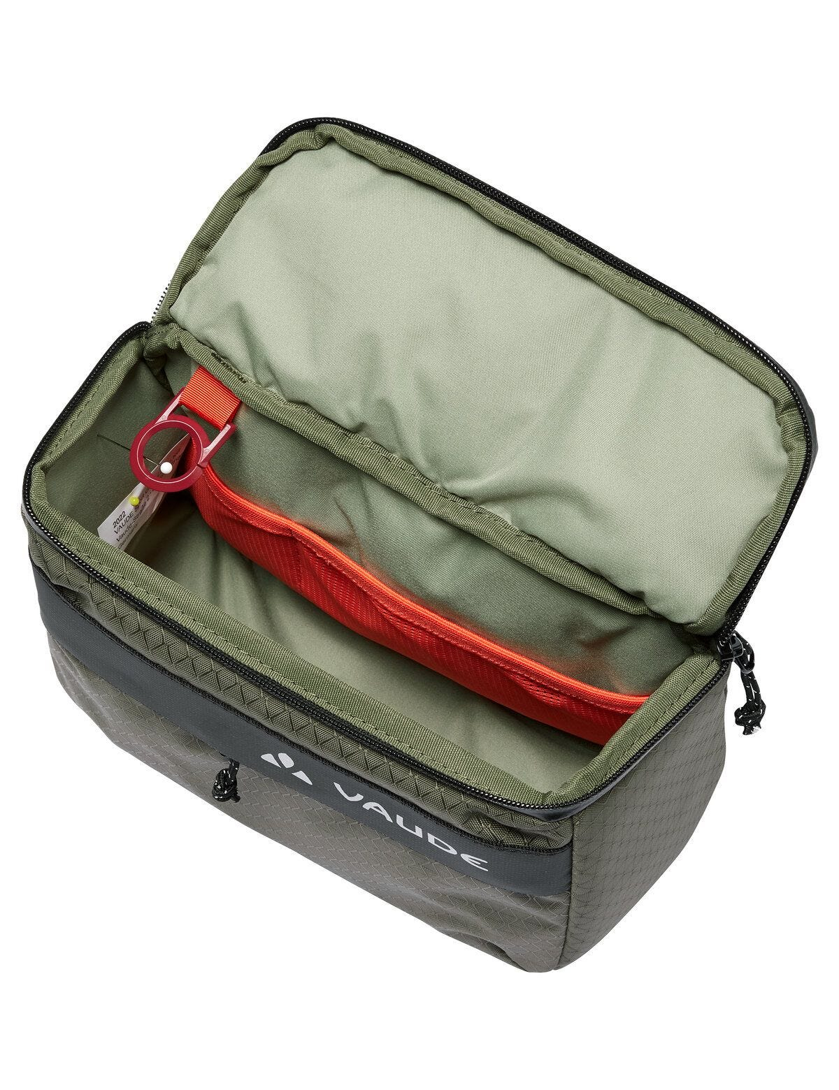 Zielona torba, otwarta, z czerwoną kieszenią z siatki. Widoczne logo Vaude.