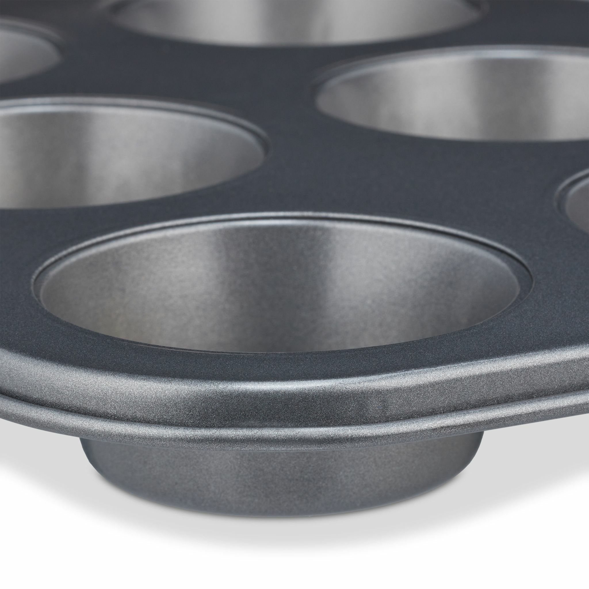 Nahaufnahme einer Muffinform mit sechs runden Formen. Graues Metall mit gewölbtem Rand.