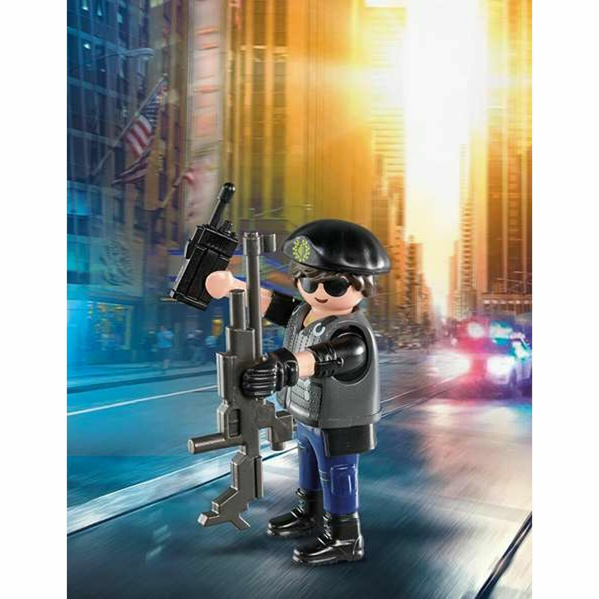 Eine Playmobil-Polizistenfigur, die ein Gewehr und ein Funkgerät hält, in einer Stadtszene.
