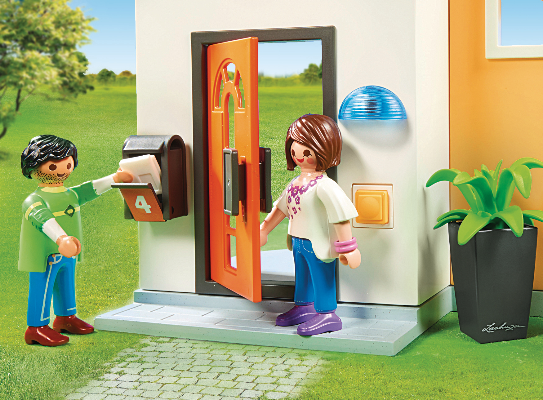 Scena Playmobil. Mężczyzna wrzuca pocztę do skrzynki. Kobieta stoi przy drzwiach. Zielona trawa dookoła.