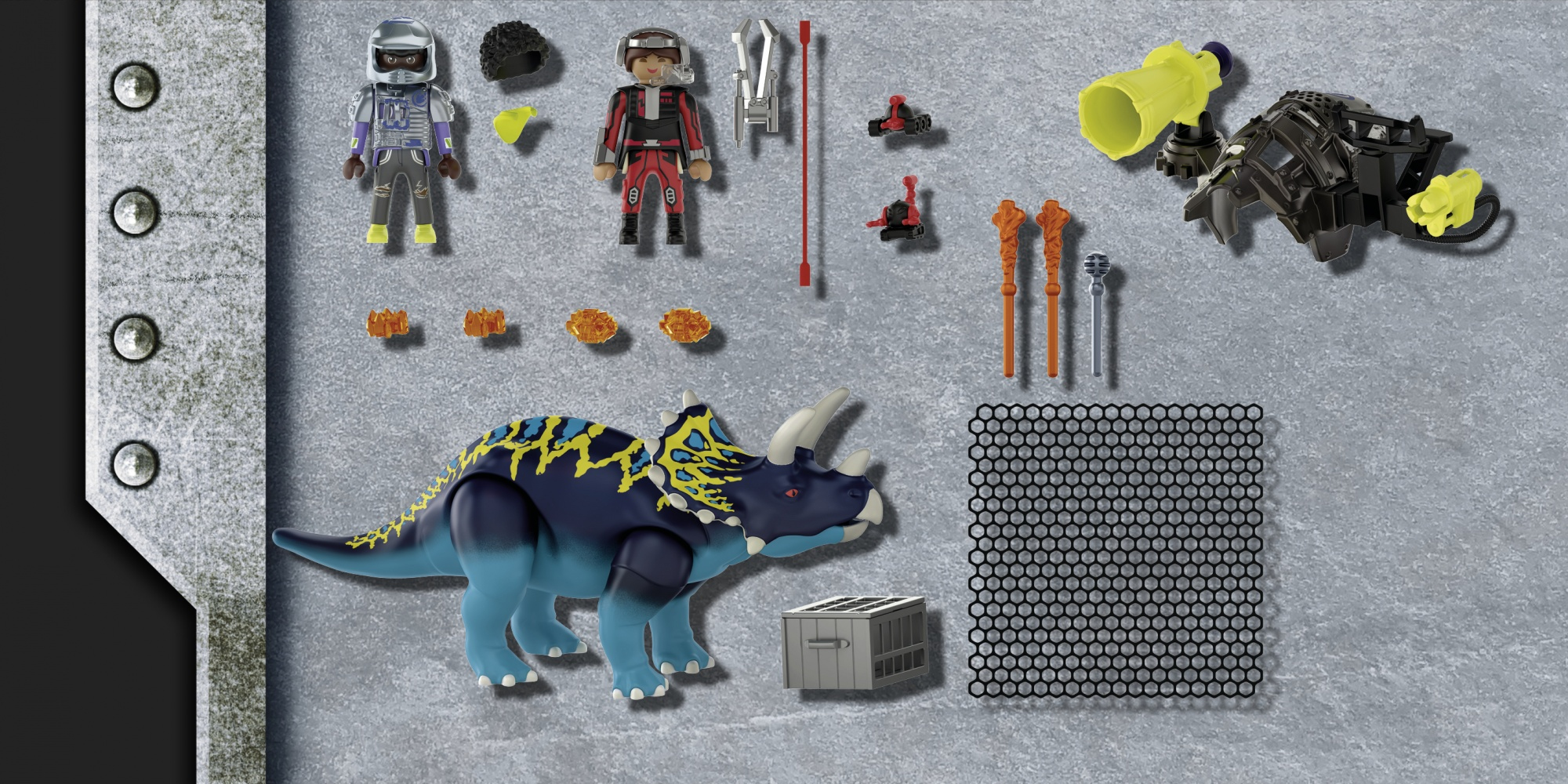 Componentes del set Playmobil Dino Rise que incluyen un Triceratops, figuras, accesorios y una jaula, sobre una superficie gris.
