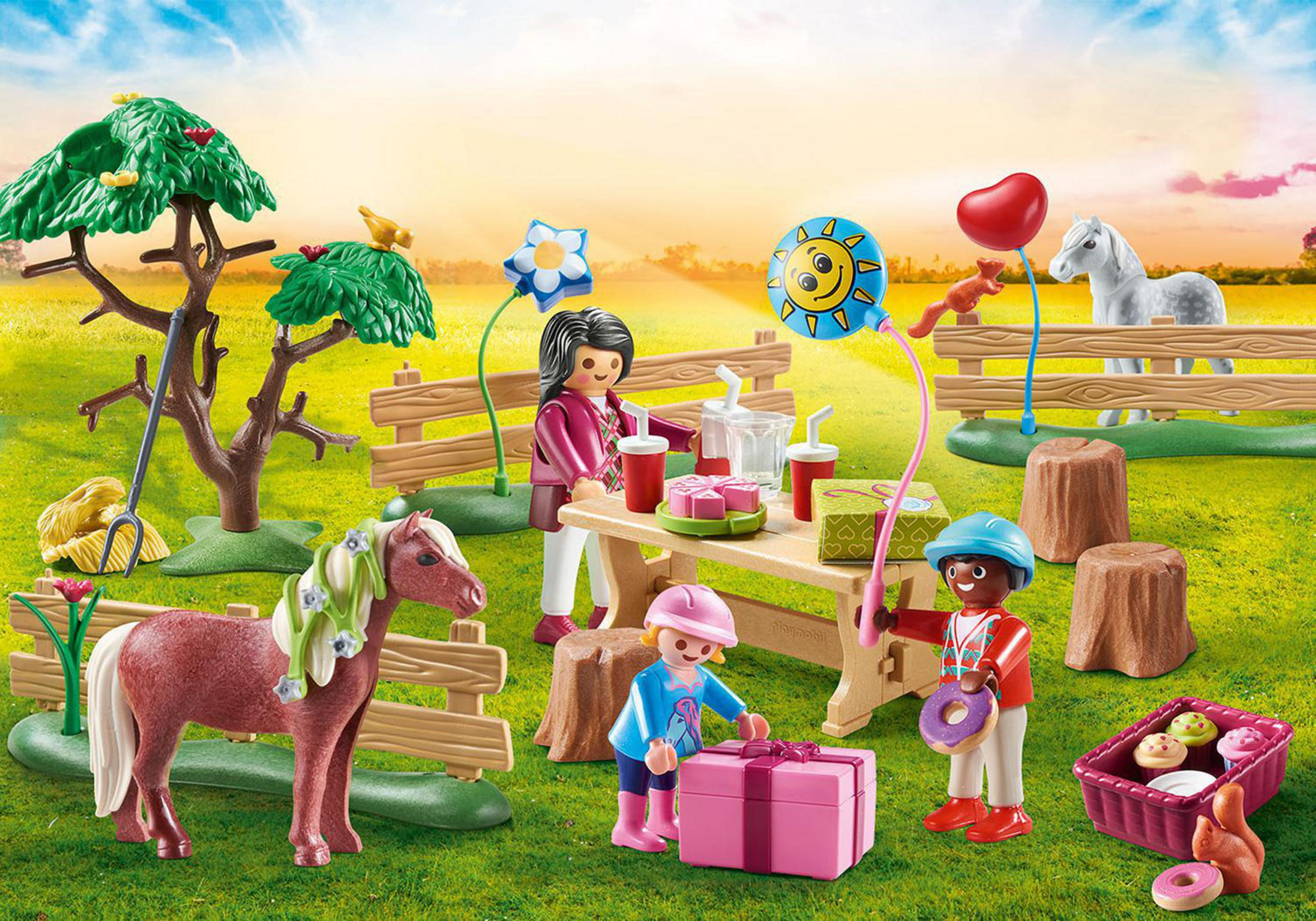 Scena piknikowa Playmobil z figurkami, stołem, prezentami, kucykiem i balonami, na zielonej łące.