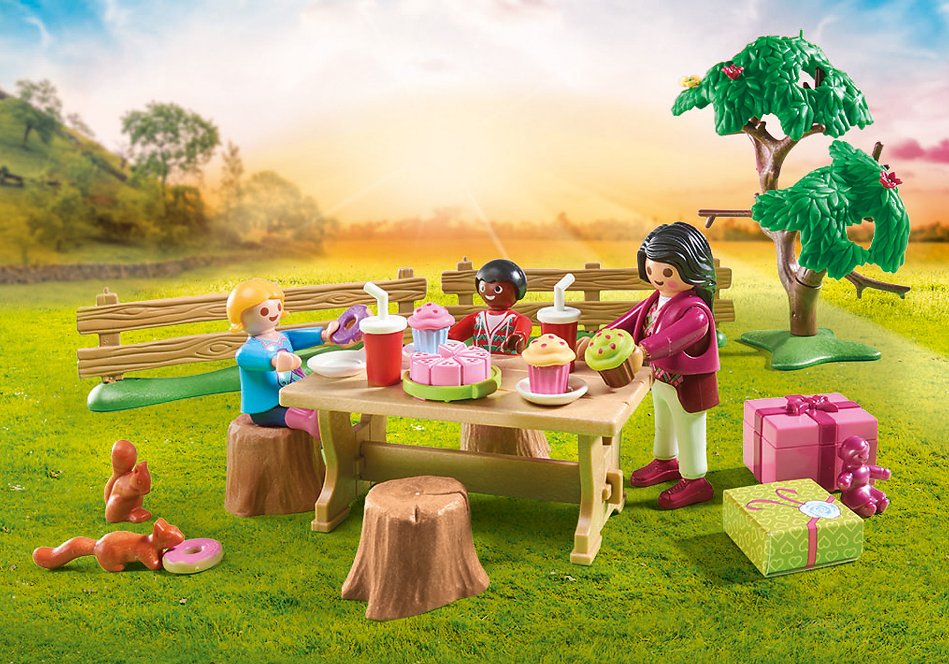 Scena piknikowa Playmobil. Ludzie, stół piknikowy, jedzenie i prezenty na trawniku.