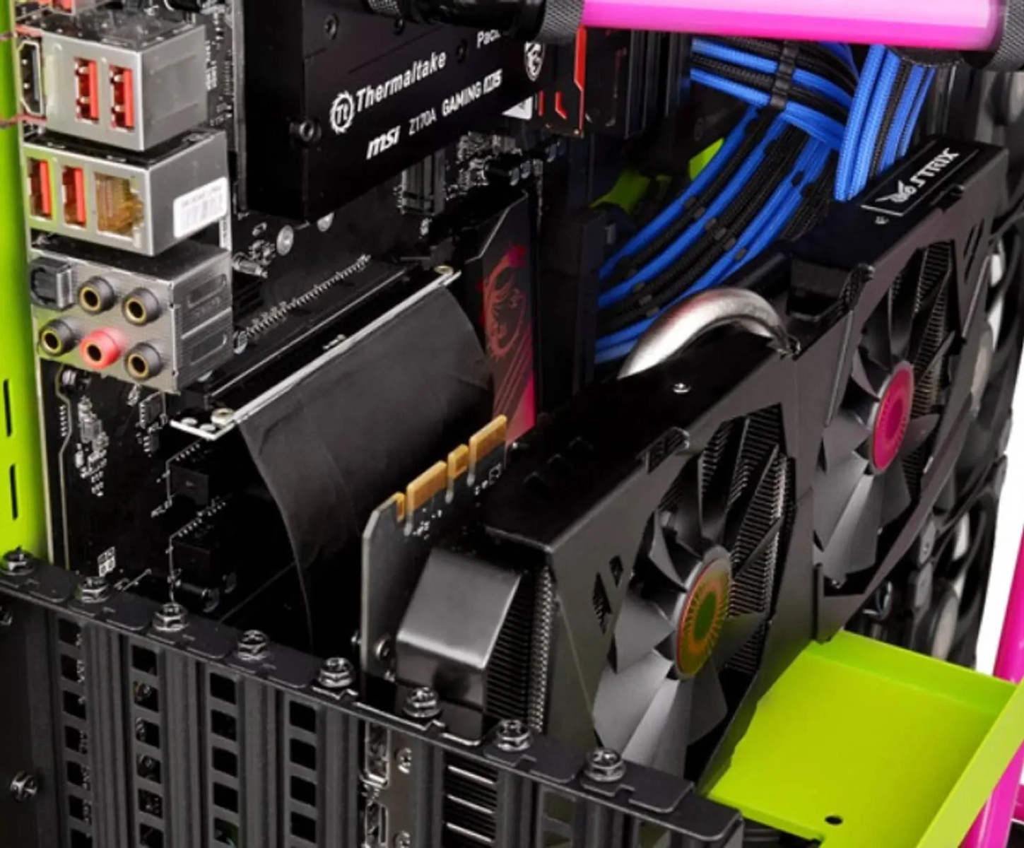 Interno computer con scheda grafica, ventole e componenti, sfondo nero.